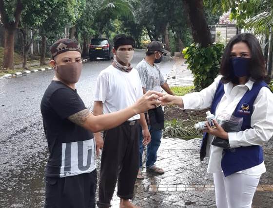 Ketua DPP Nasdem Bidang Lingkungan Hidup Lusyani Suwandi membagikan hand sanitizer kepada masyarakat di Jakarta.