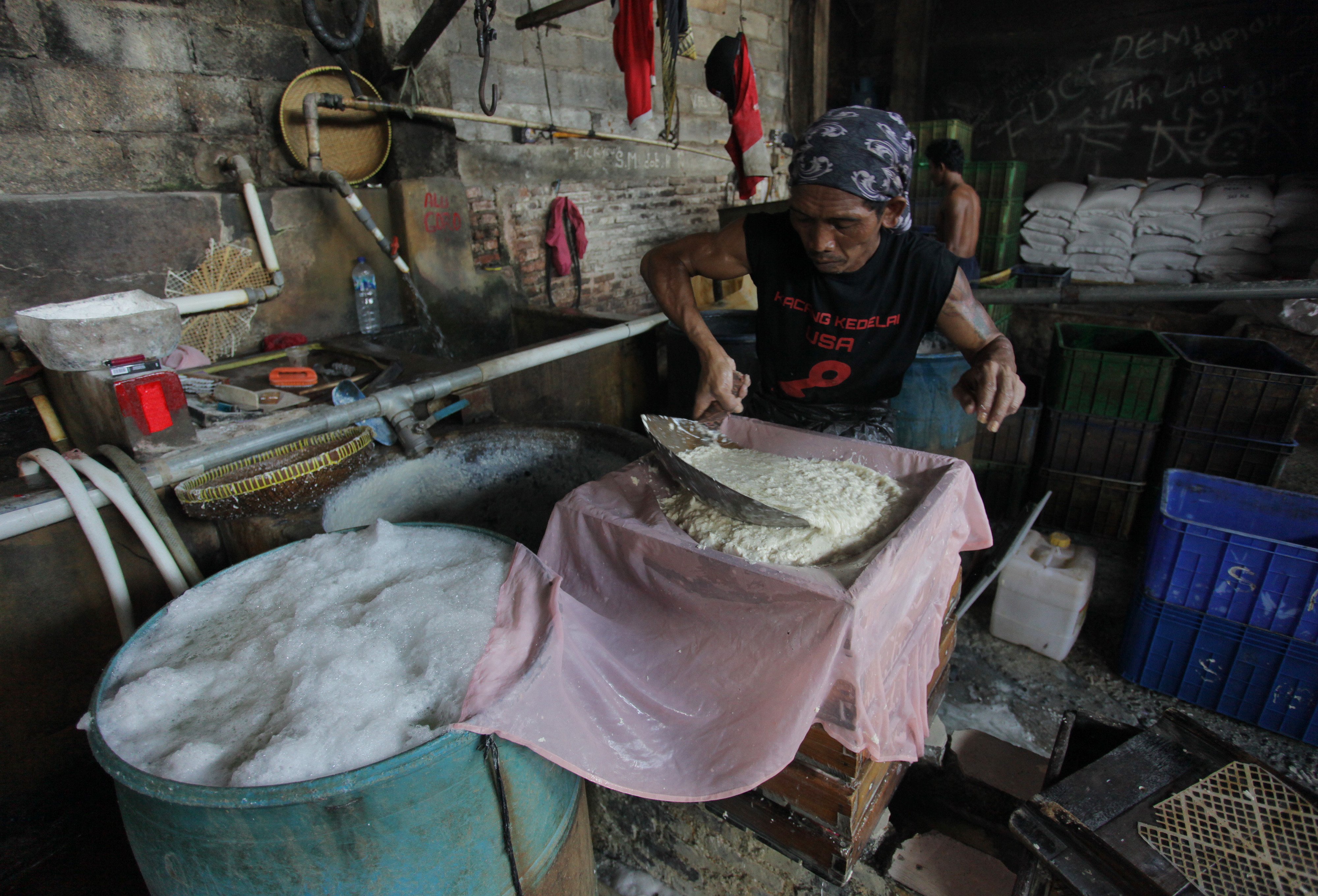 Pekerja memproduksi tahu di sebuah industri rumahan di kawasan Lebak Bulus, Jakarta