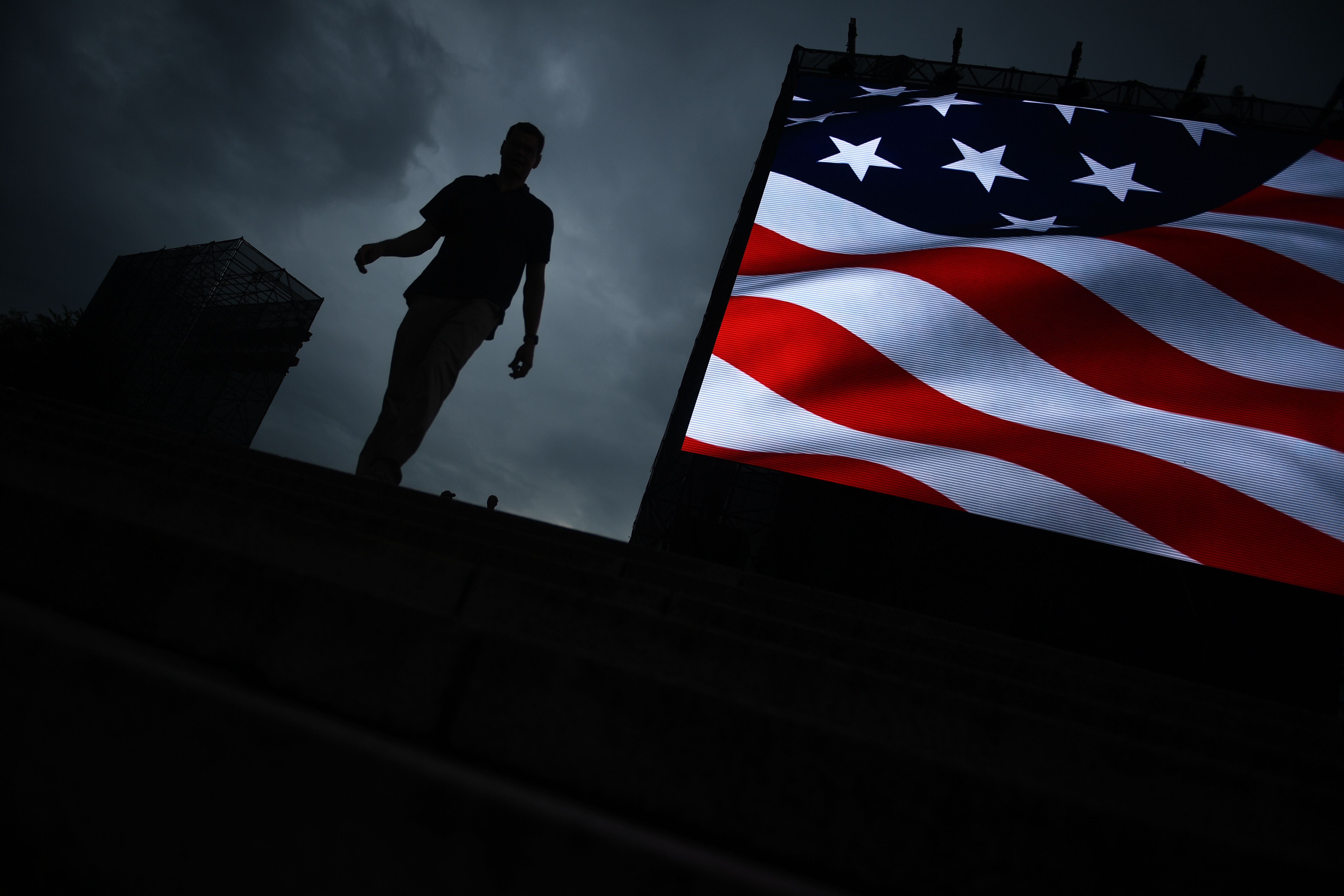  Seorang warga melintasi layar besar yang menampilkan bendera Amerika Serikat (AS).