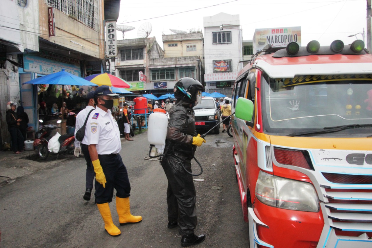 Petugas melakukan penyemprotan angkutan umum di Pasar Horas, Kota Pematangsiantar, Sumut, Jumat (3/4/2020).
