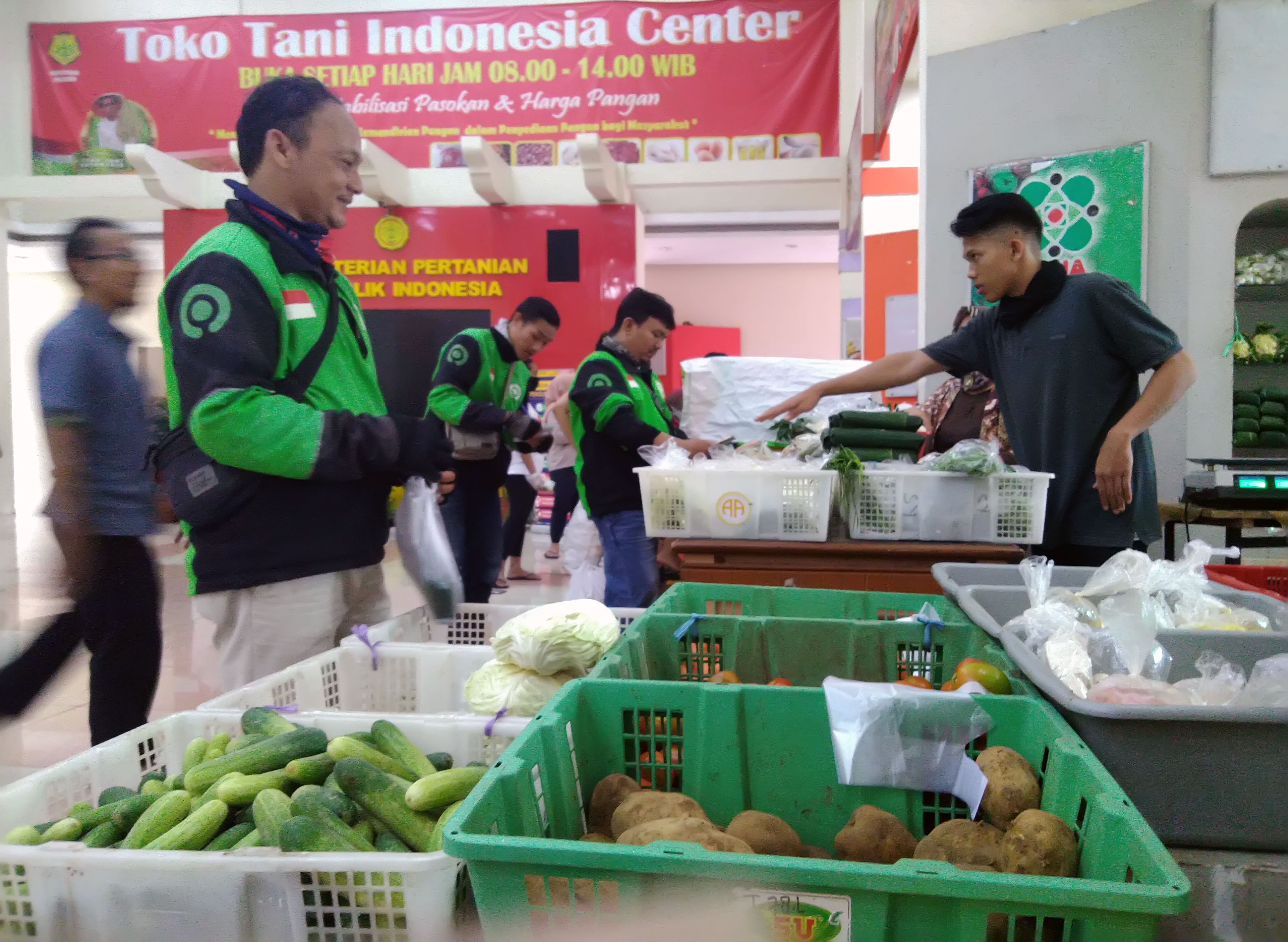Warga dan pengemudi ojek daring antre membeli bahan makanan di Toko Tani Indonesia Center (TTIC) Pasar Minggu, di Jakarta, Sabtu (4/4/2020).