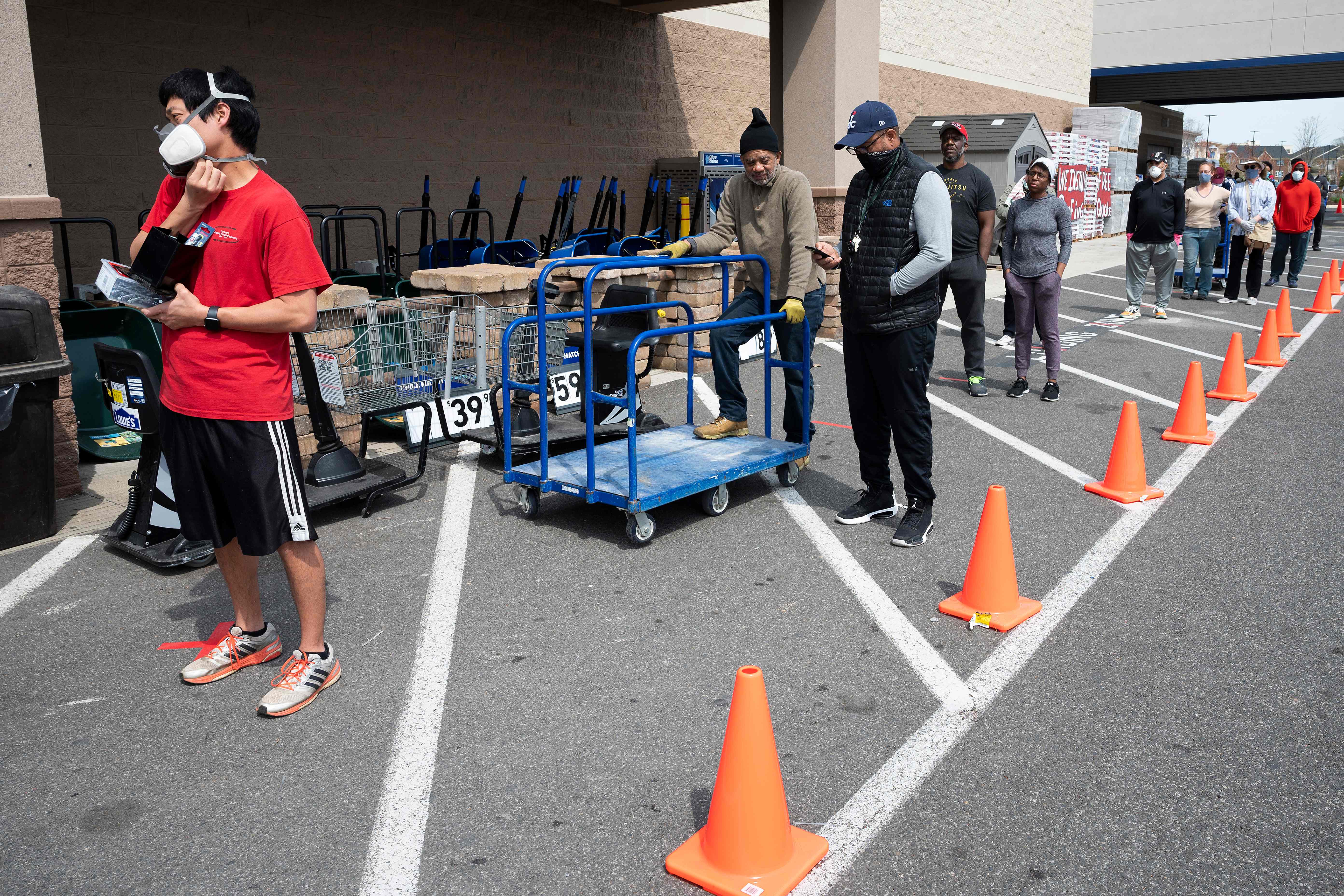 Warga mengenakan masker dan menjaga jarak saat antre untuk masuk ke sebuah supermarket di Washington, AS.
