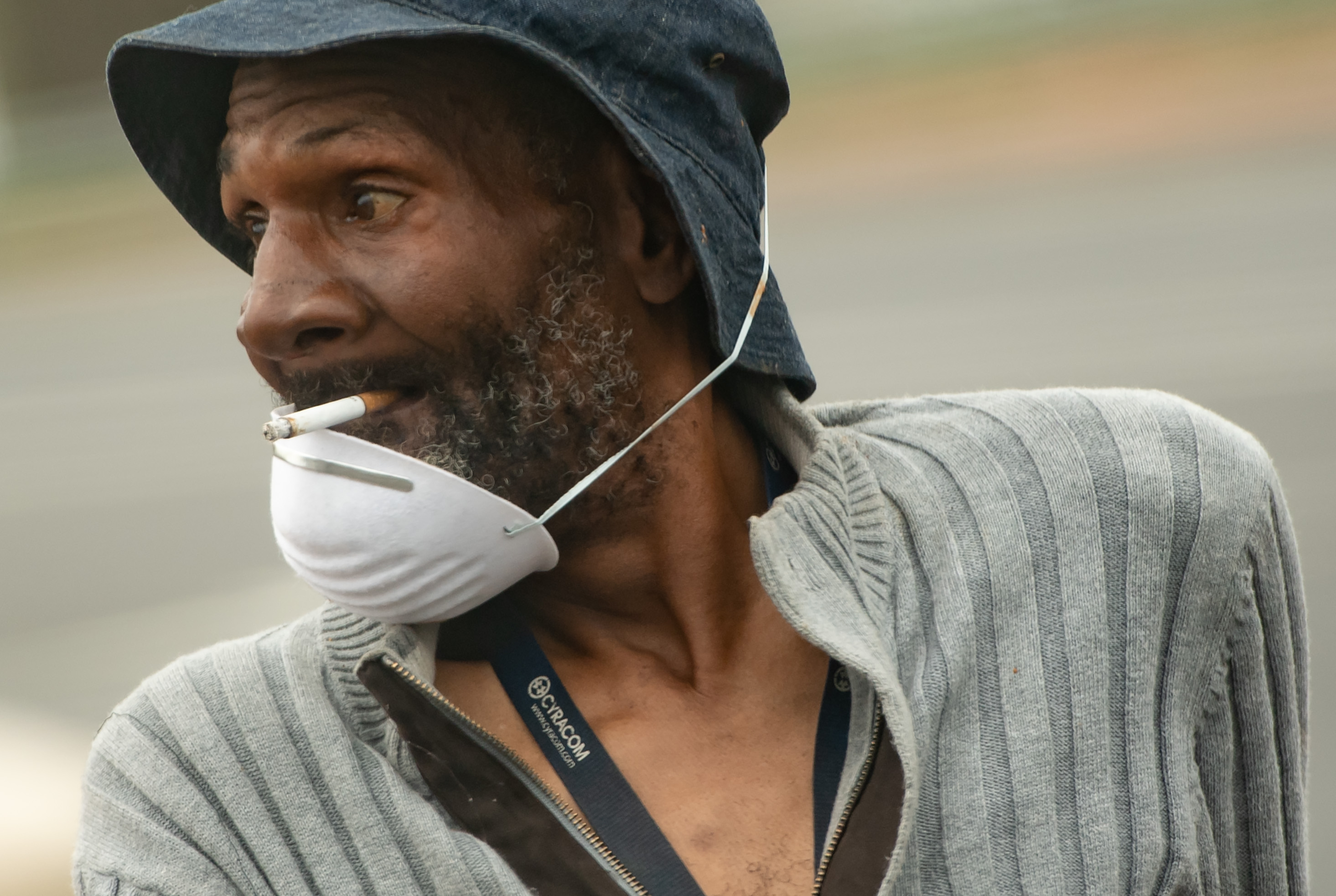 Seorang pria di Washington DC, Amerika Serikat, mengenakan masker sembari merokok.