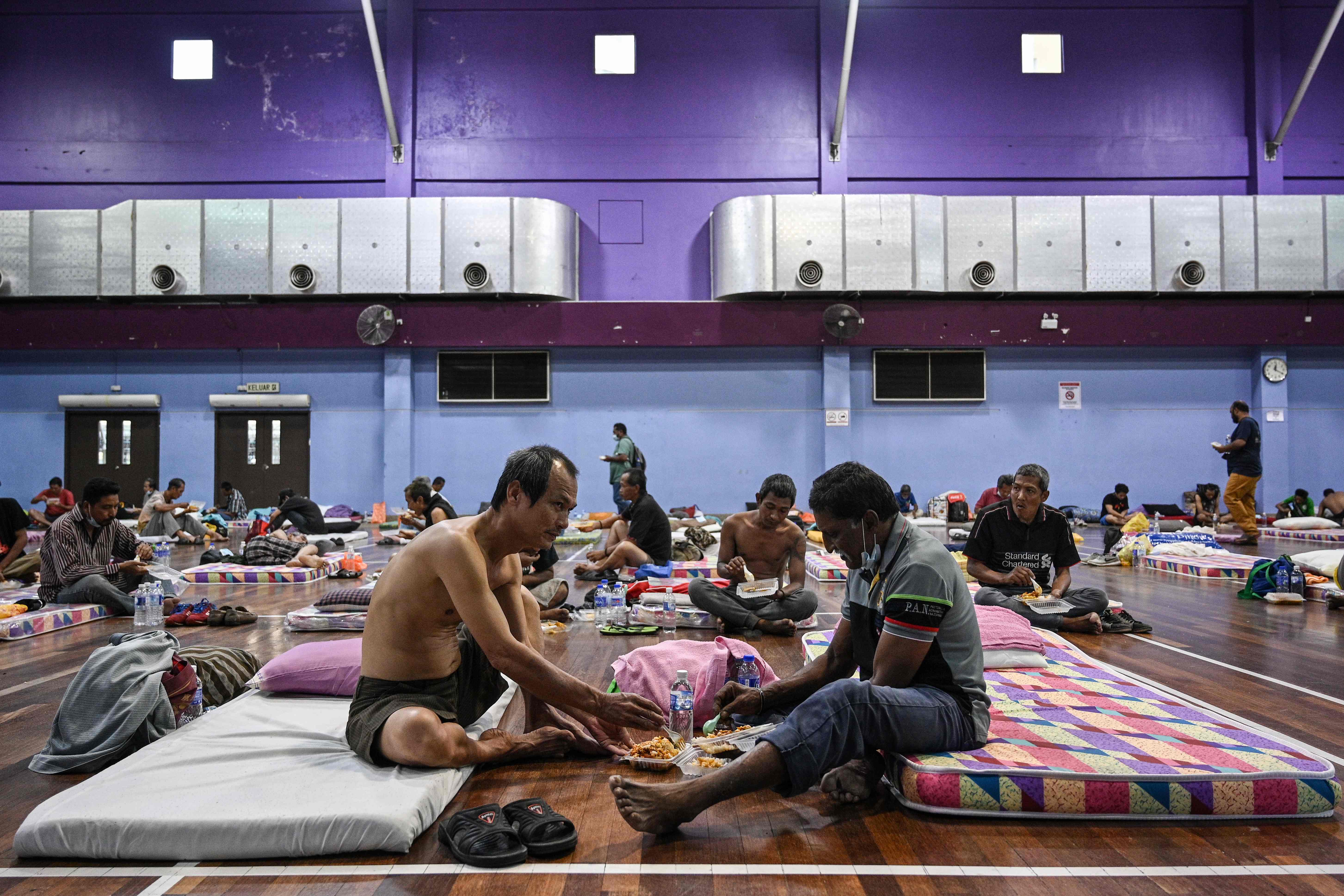 Para tuna wisma mempraktikkan jarak sosial ketika mereka makan siang di tempat penampungan sementara di Kuala Lumpur, Malaysia, Kamis (2/4).