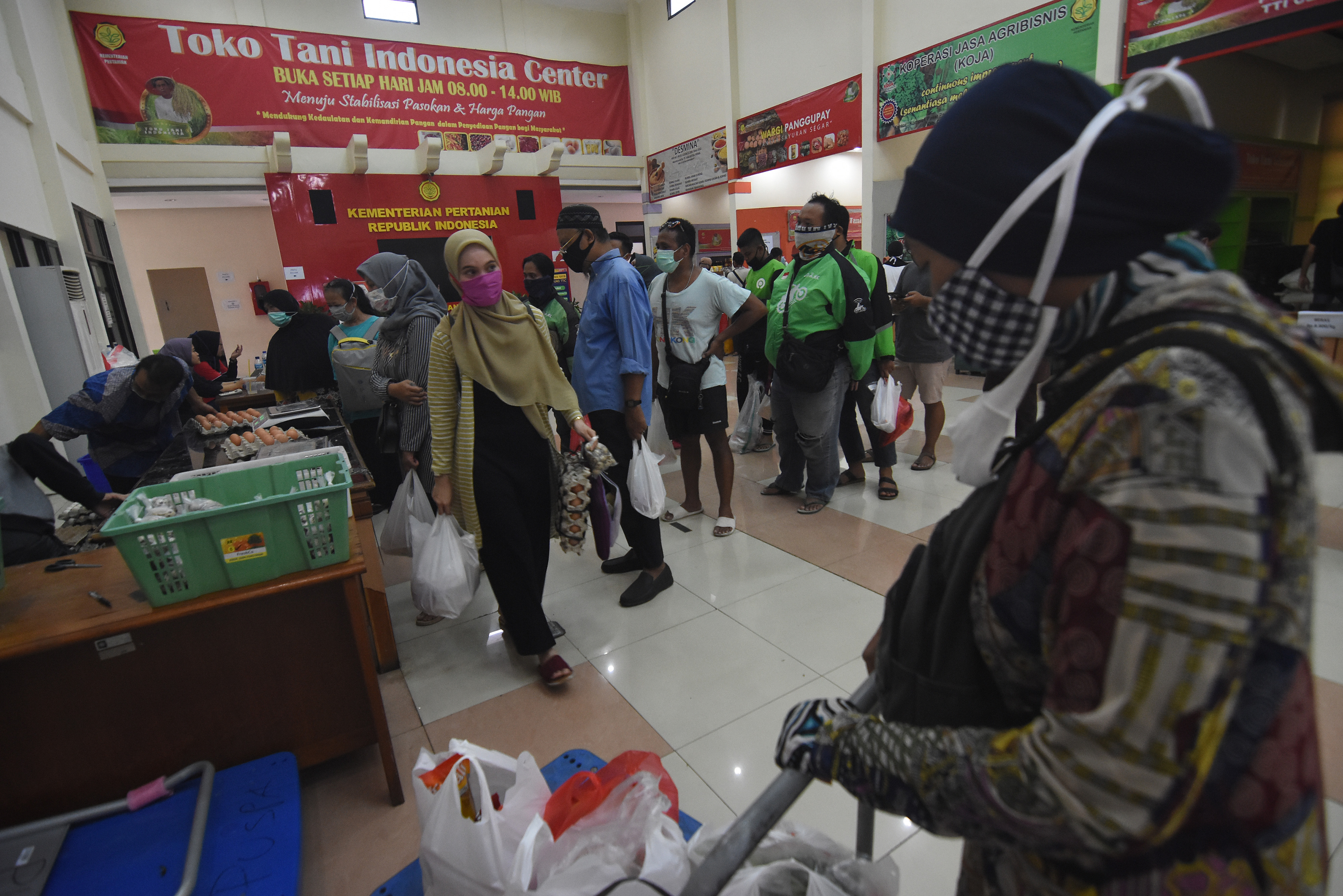 Warga dan pengemudi ojek daring berbelanja kebutuhan pangan di Toko Tani Indonesia Center milik Kementerian Pertanian di Jakarta