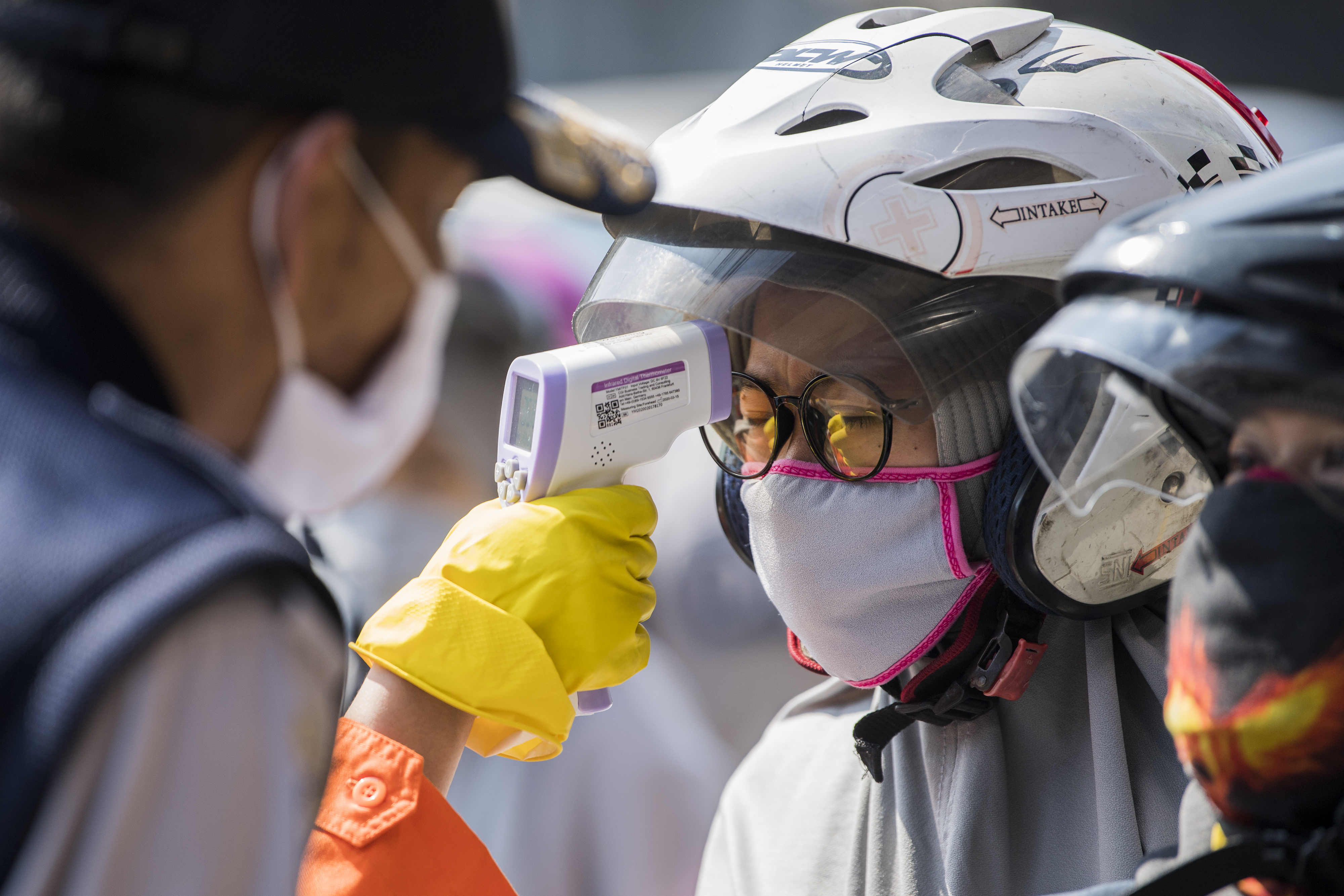 Petugas memeriksa suhu tubuh warga di Bandung, Jawa Barat, Rabu (22/4/2020).