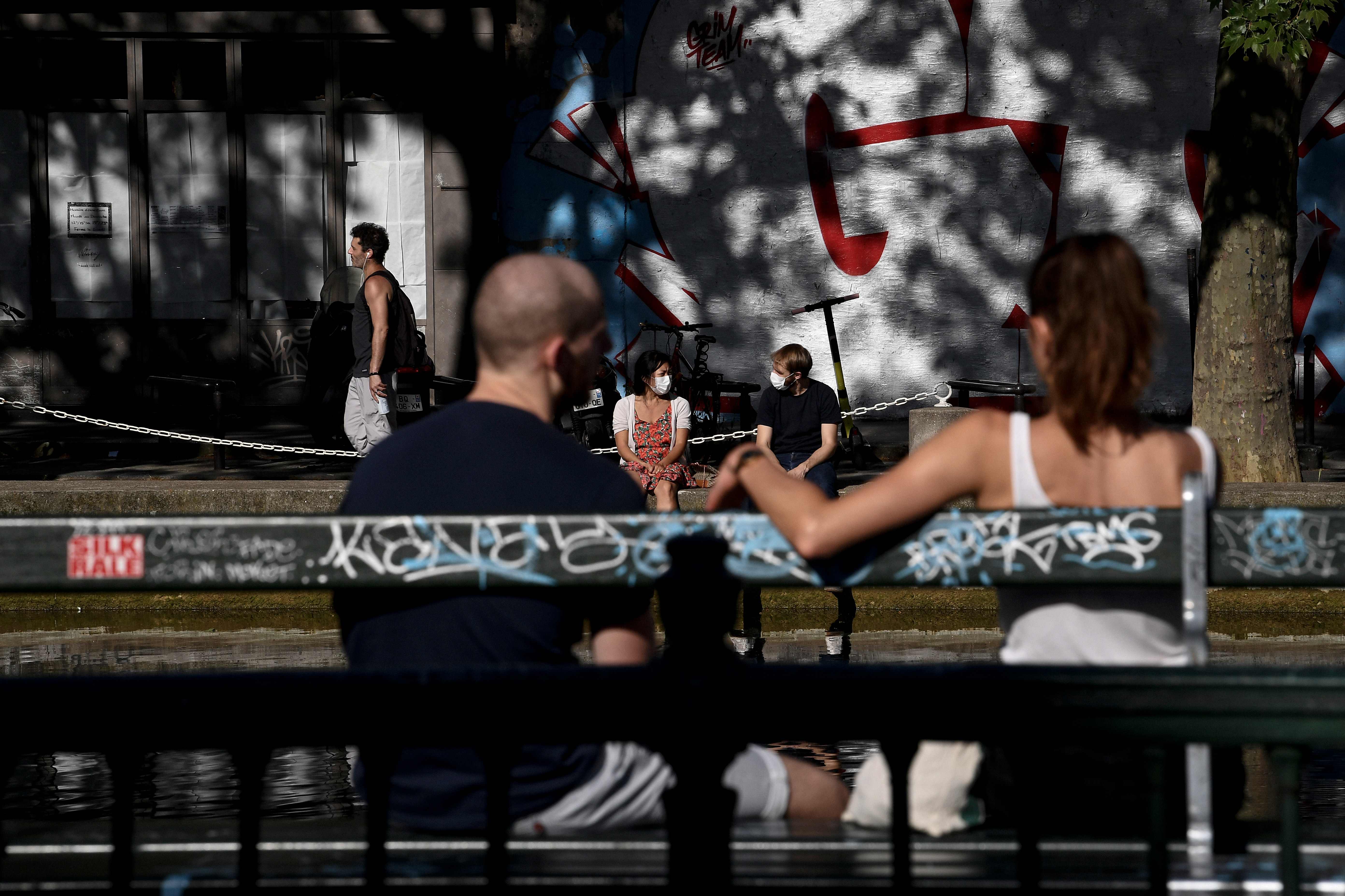 Warga bersantai di tepi Canal Saint-Martin di Paris, Prancis, saat pemberlakuan lockdown di negara itu.