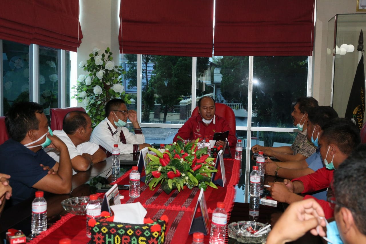 Bupati Tapanuli Utara Nikson Nababan (tengah) memimpin rapat kepala desa terkait pengetatan pengawasan kesehatan.