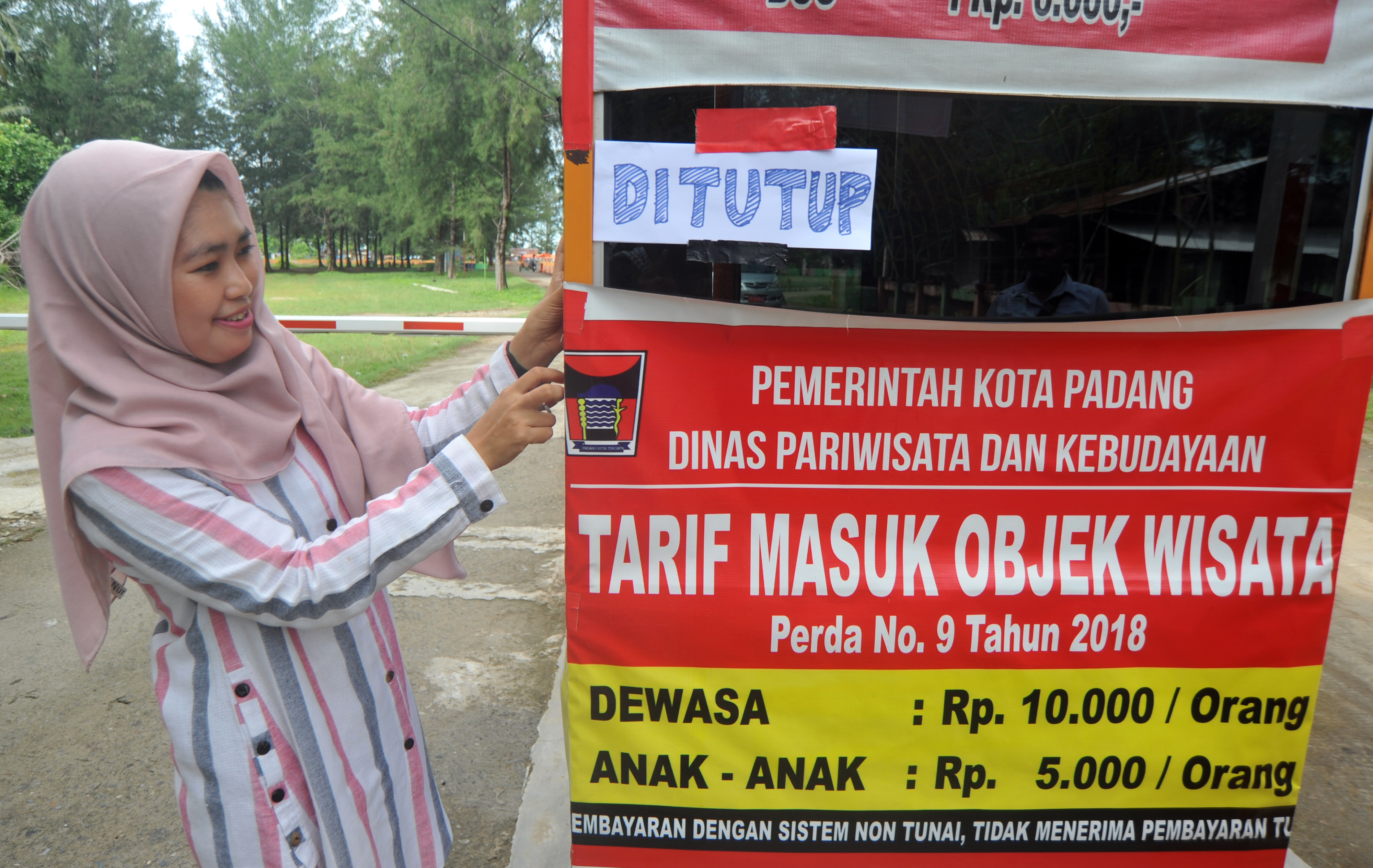 Petugas memasang pengumuman tanda ditutupnya objek wisata Pantai Air Manis, di Padang, Sumbar (20/3)