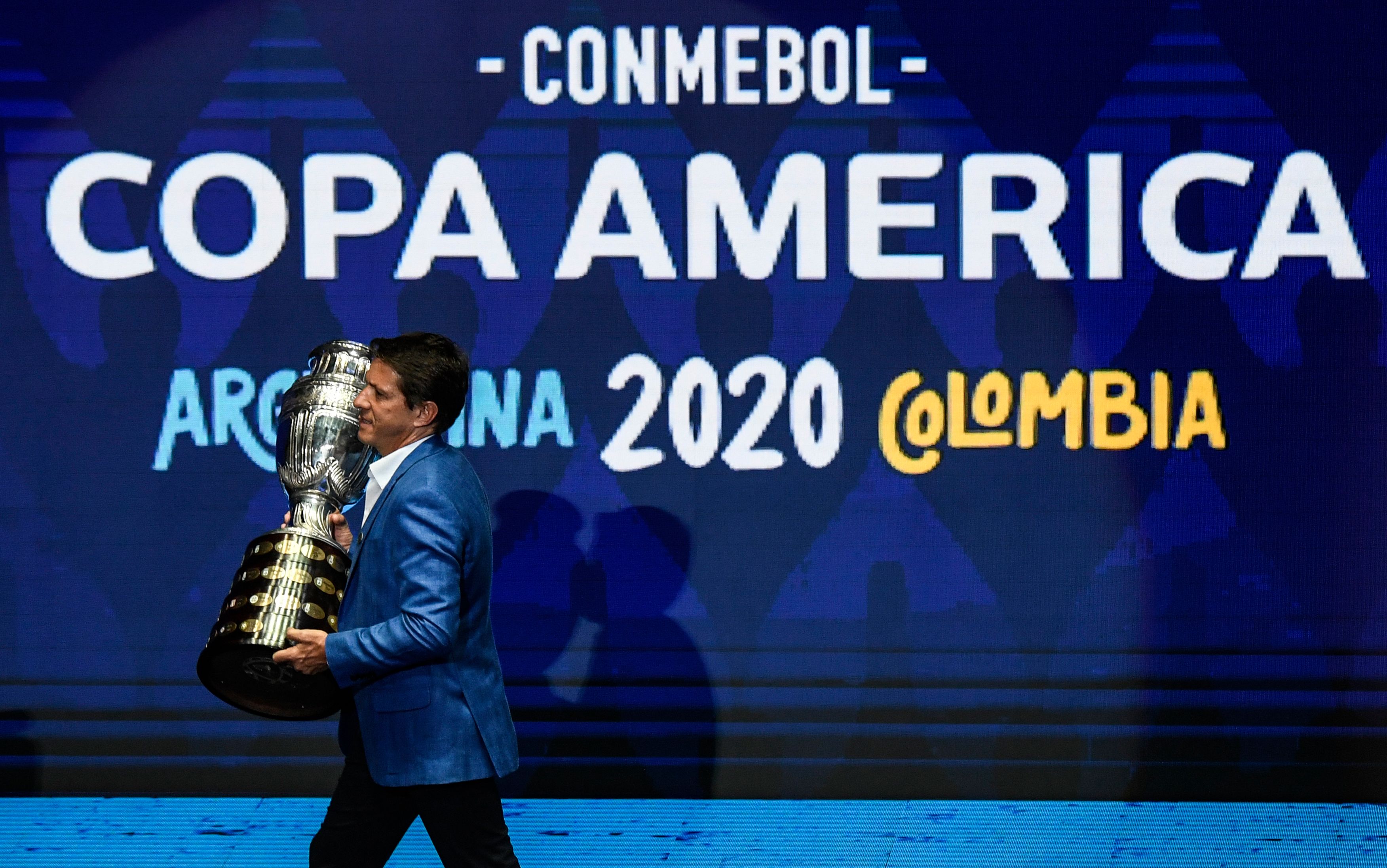 Mantan pesepak bola Brasil Juninho Paulista membawa trofi Copa America saat drawing, Desember lalu.