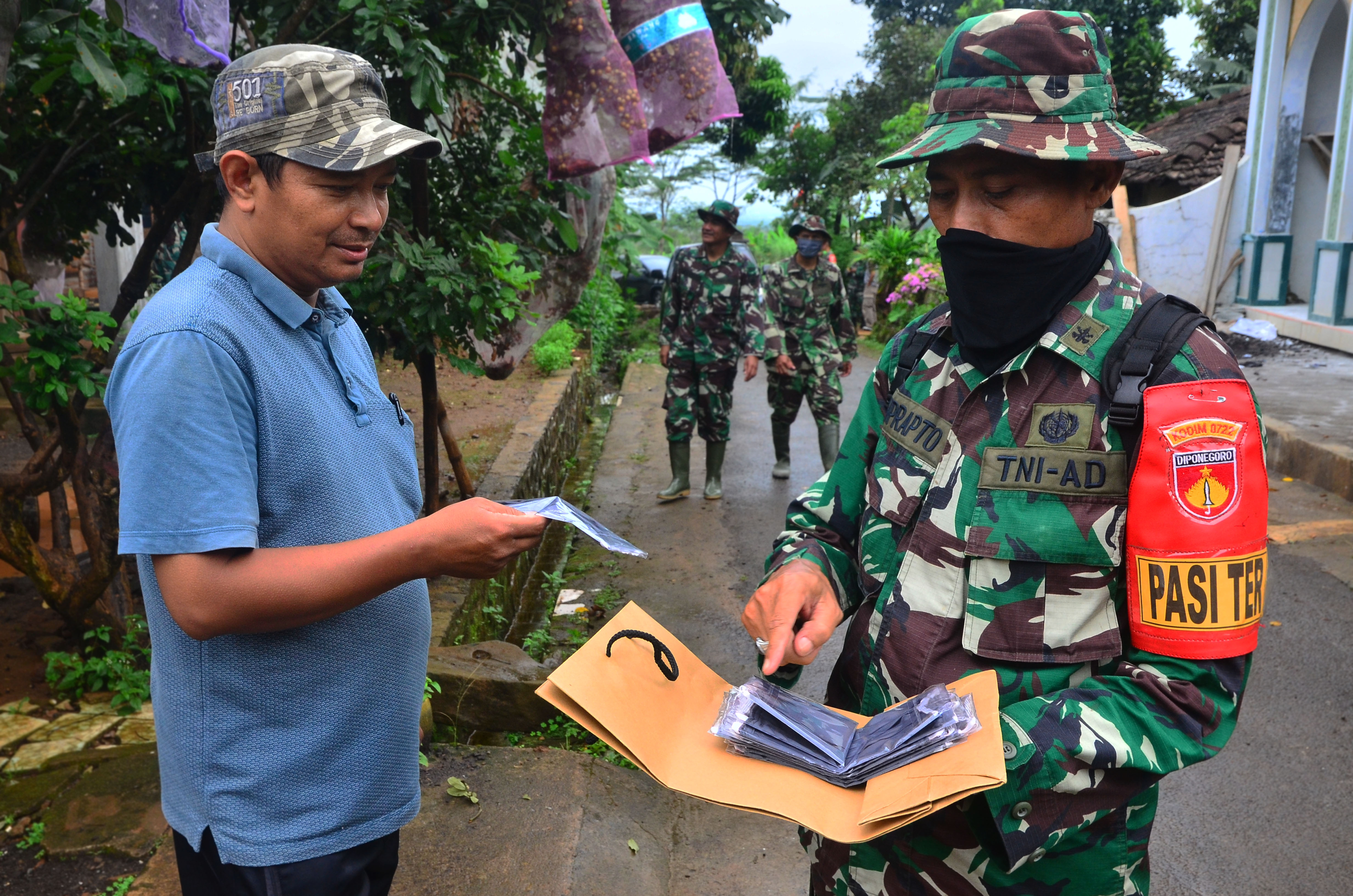 TNI membagikan masker untuk masyarakat dalam mencegah Covid-19. 