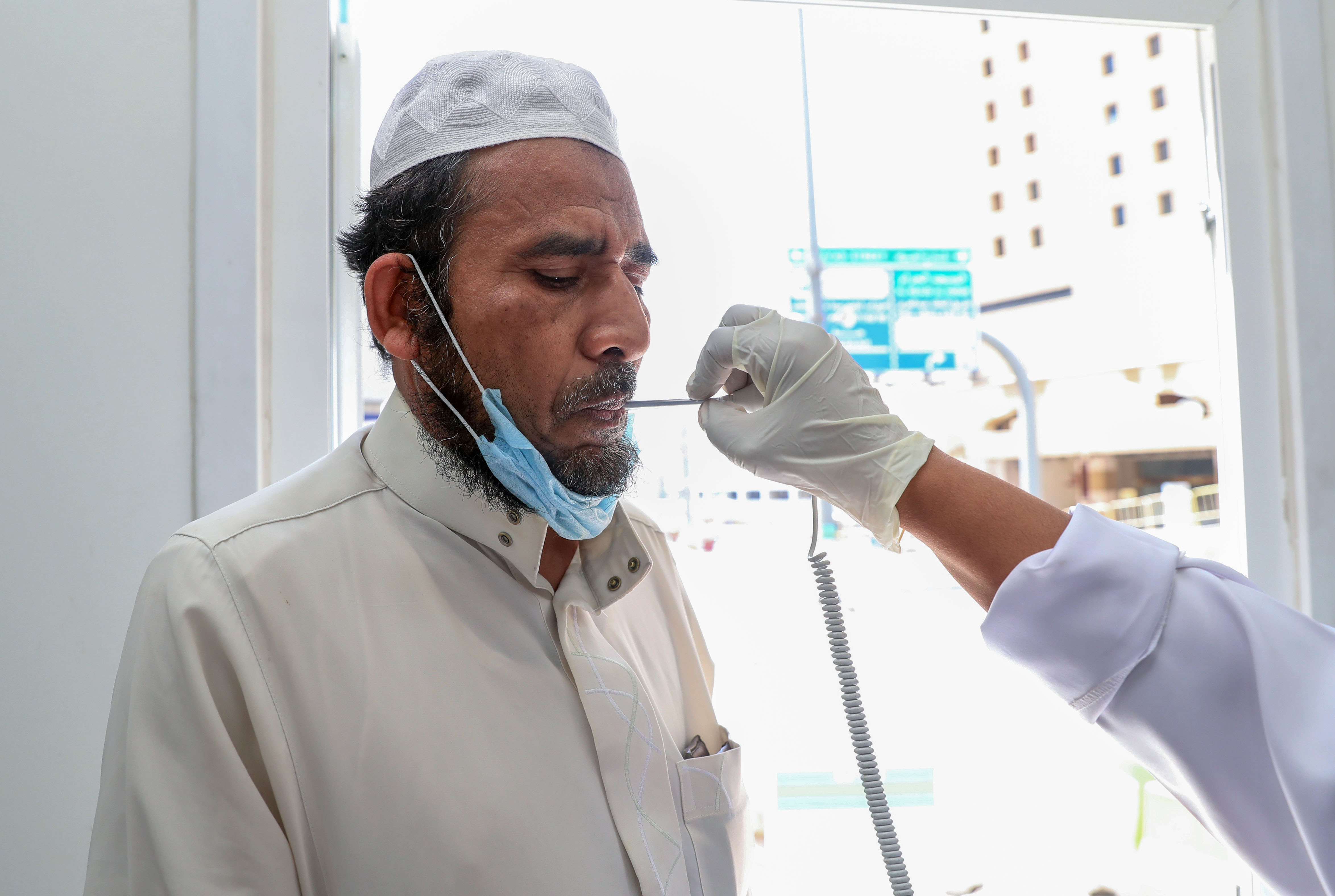 Seorang warga diperiksa suhu tubuhnya di sebuah klinik di Mekah, Arab Saudi.
