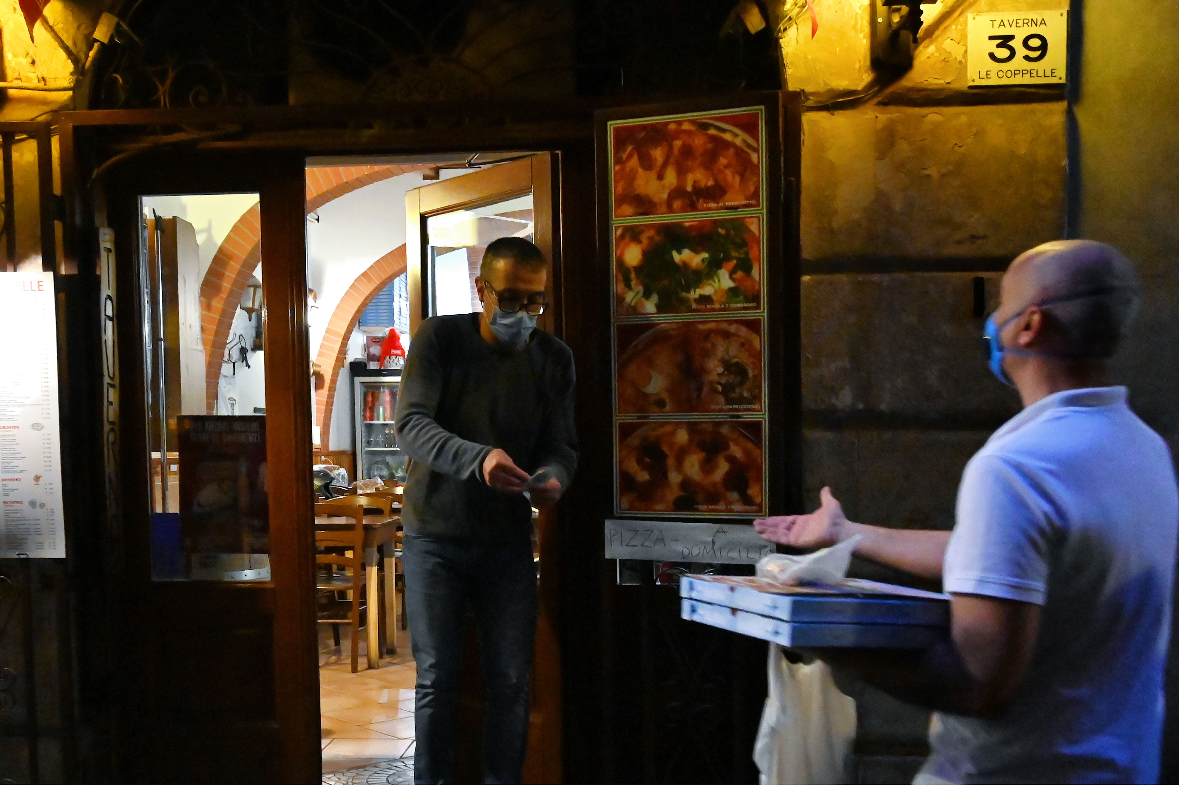 Seorang warga membeli piza di Roma, Italia.