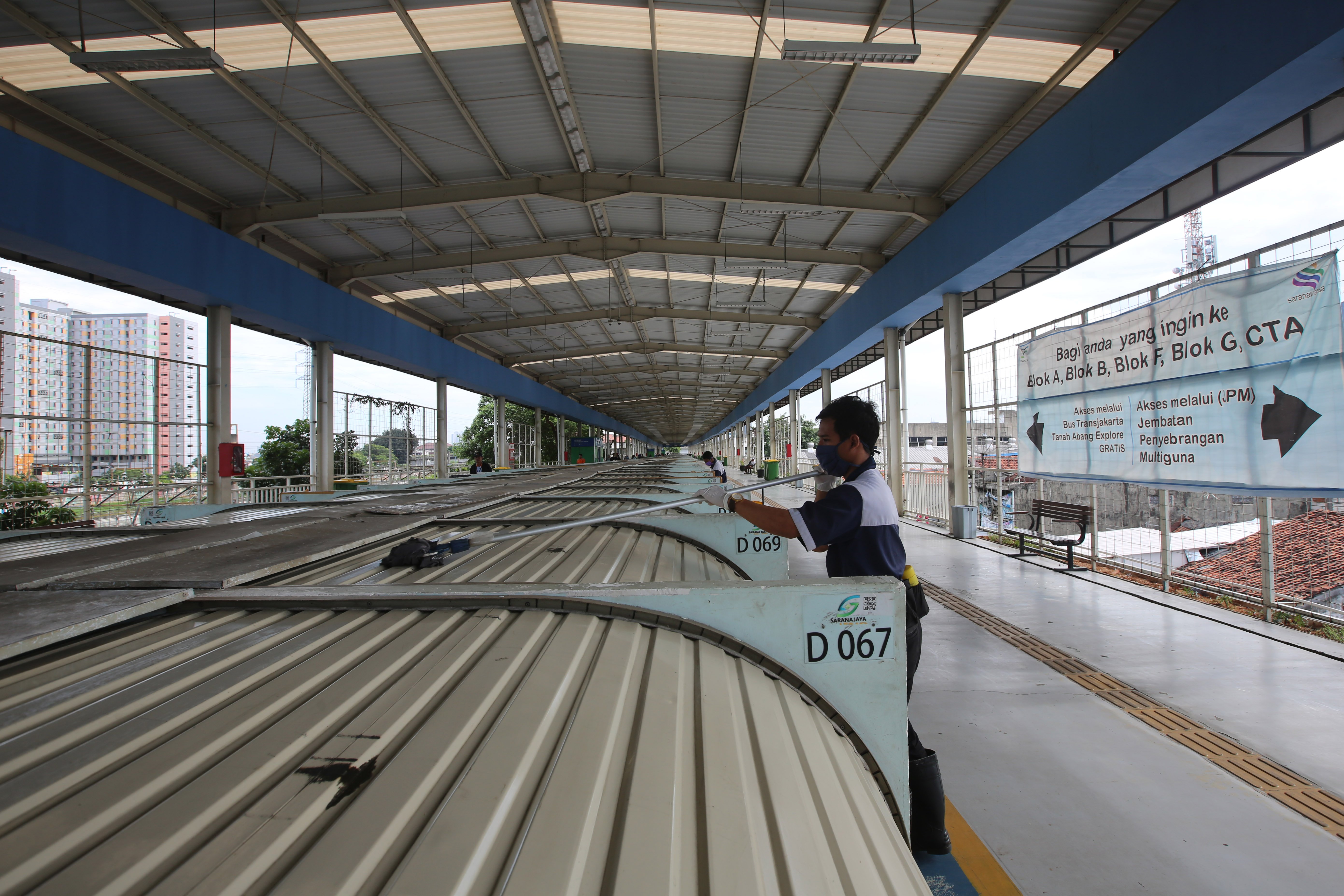Petugas membersihkan penutup kios saat pasar tutup sementara di Jkybridge Tanah Abang, Jakarta Pusat, Rabu (1/4/2020)