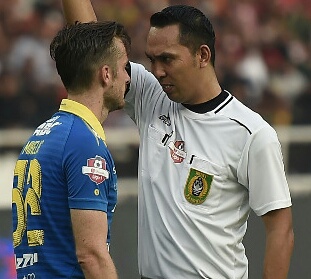 Wasit Fariq Hitaba (kanan) saat memberi kartu kuning pada pesepak bola Persib Bandung Rene Mihelic (kiri).