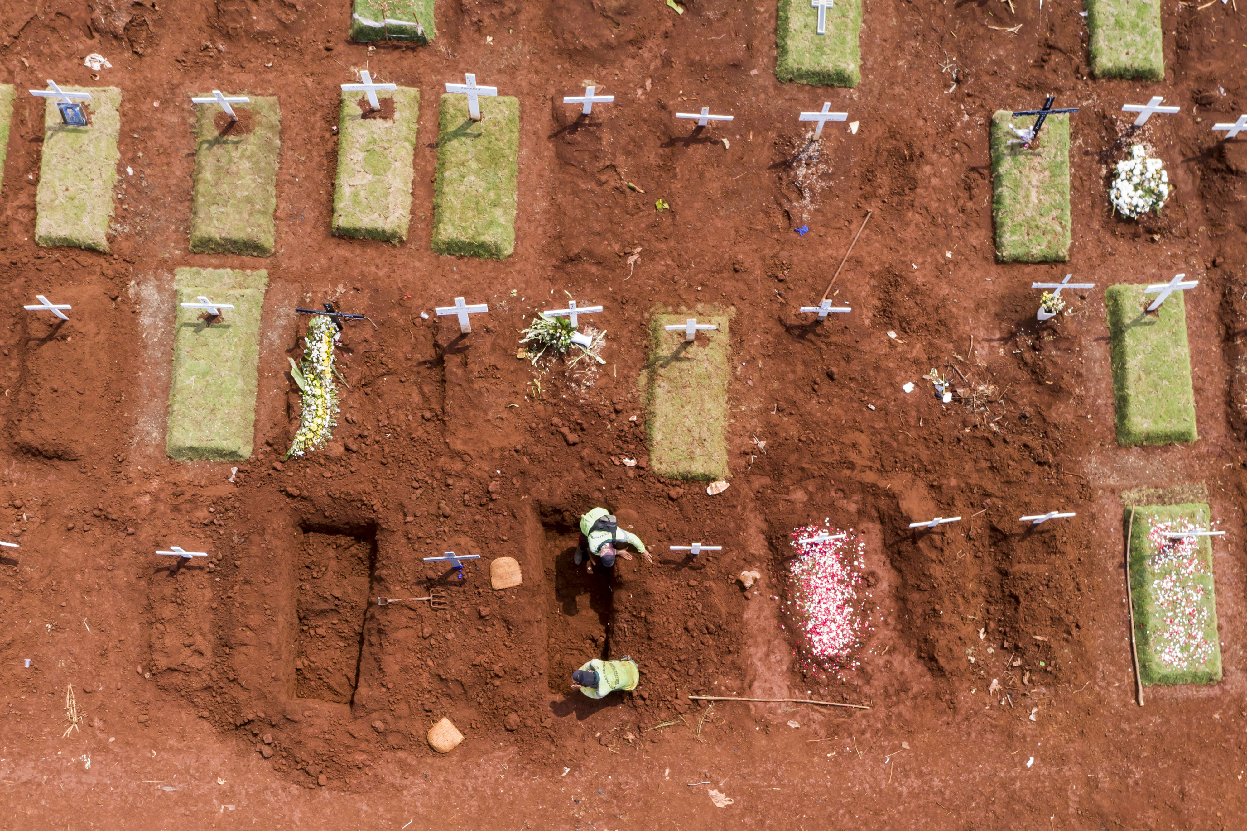  Petugas pemakaman menggali liang kubur untuk jenazah kasus COVID-19 di TPU Pondok Ranggon, Jakarta, Minggu (26/4).