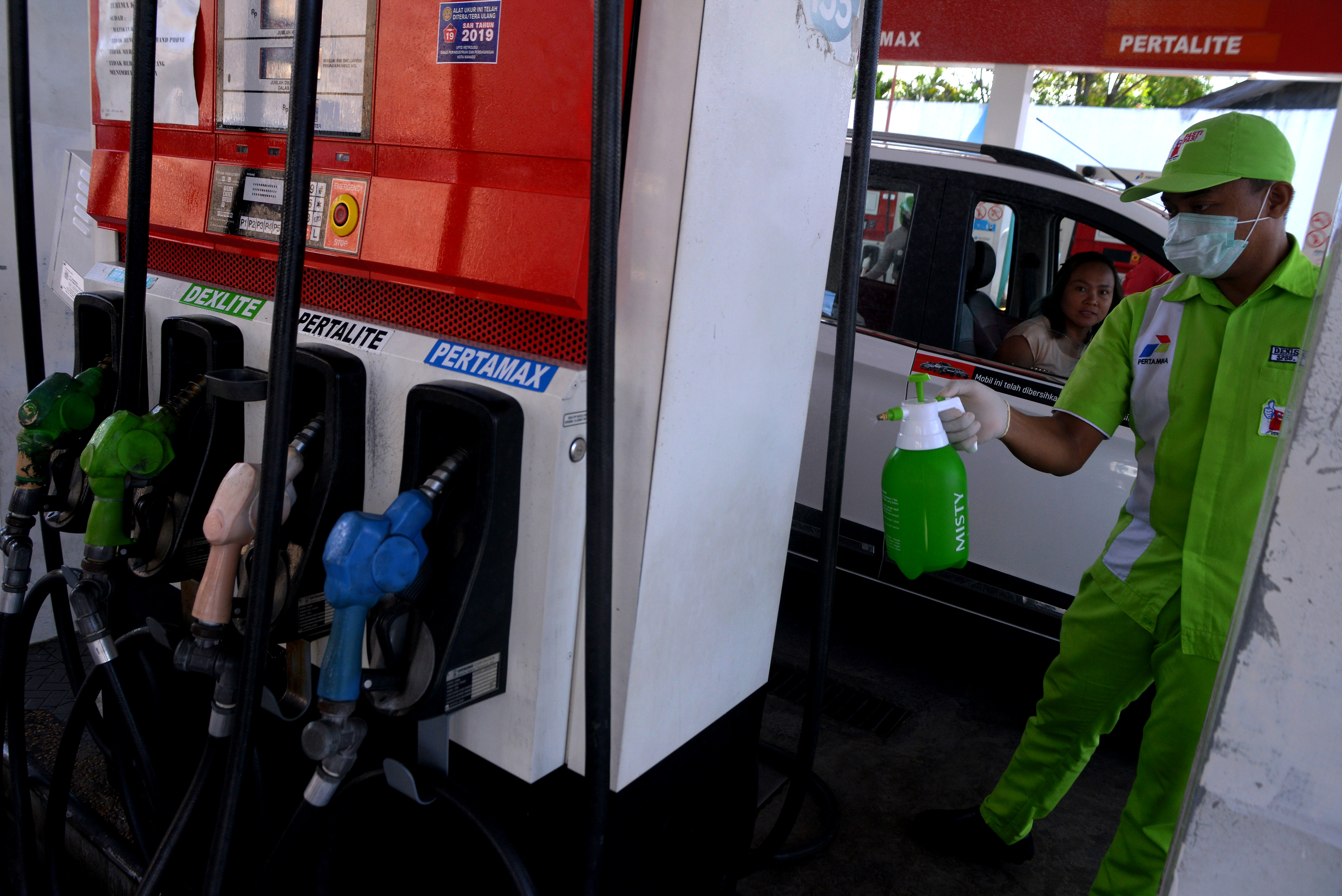 Petugas menyemprotkan cairan disinfektan di SPBU Pertamina untuk mencegah penyebaran virus korona.