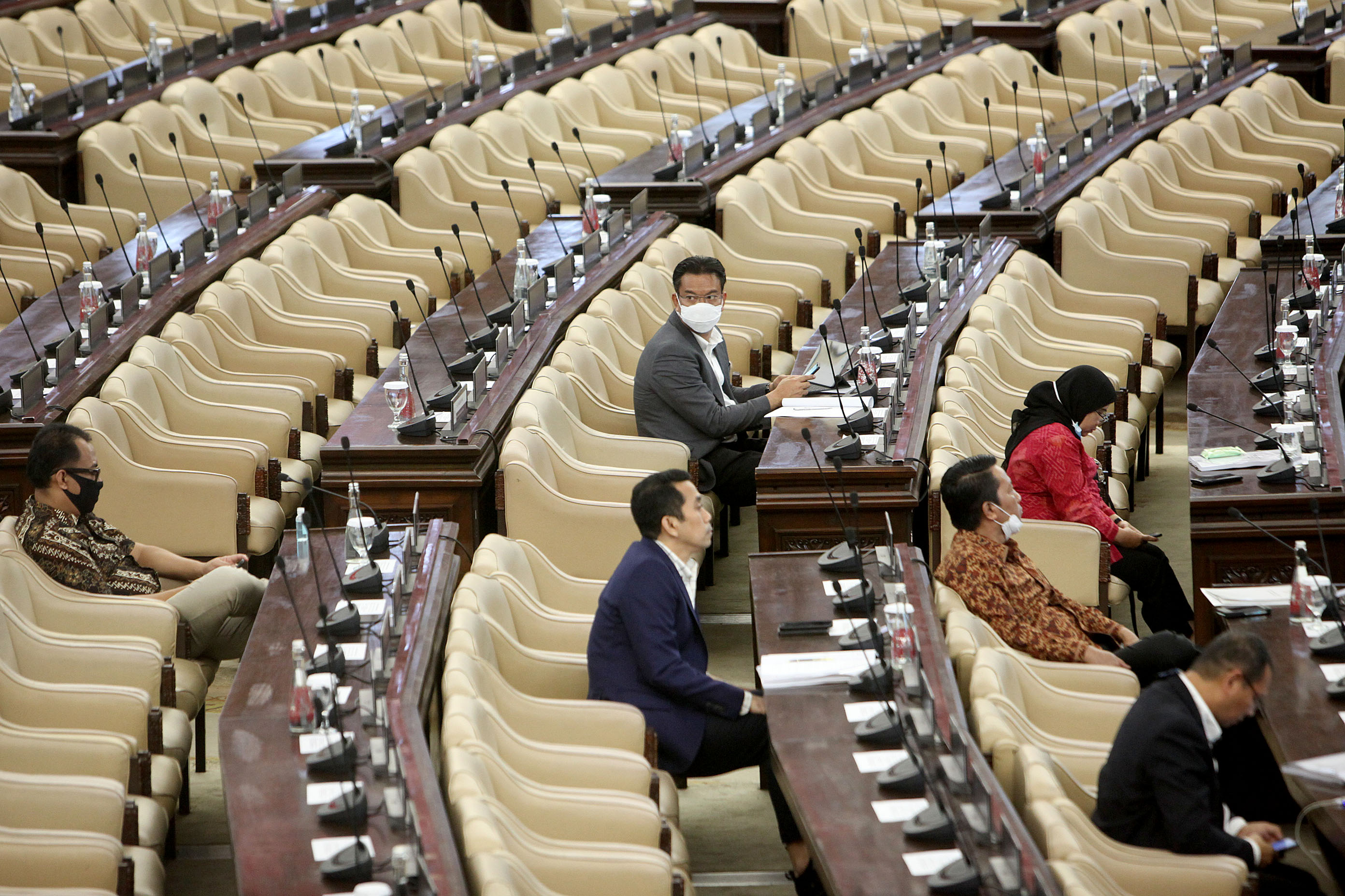 Anggota dewan mengenakan masker saat hadir dalam rapat paripurna yang dilakukan secara virtual di gedung Nusantara DPR.