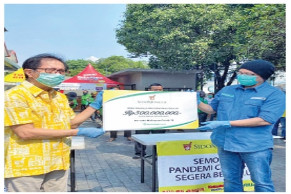 Direktur Sido Muncul Irwan Hidayat (kiri) menyerahkan bantuan kepada Founder sekaligus CEO benihbaik. com, Andy F Noya, di Jakarta, kemarin.