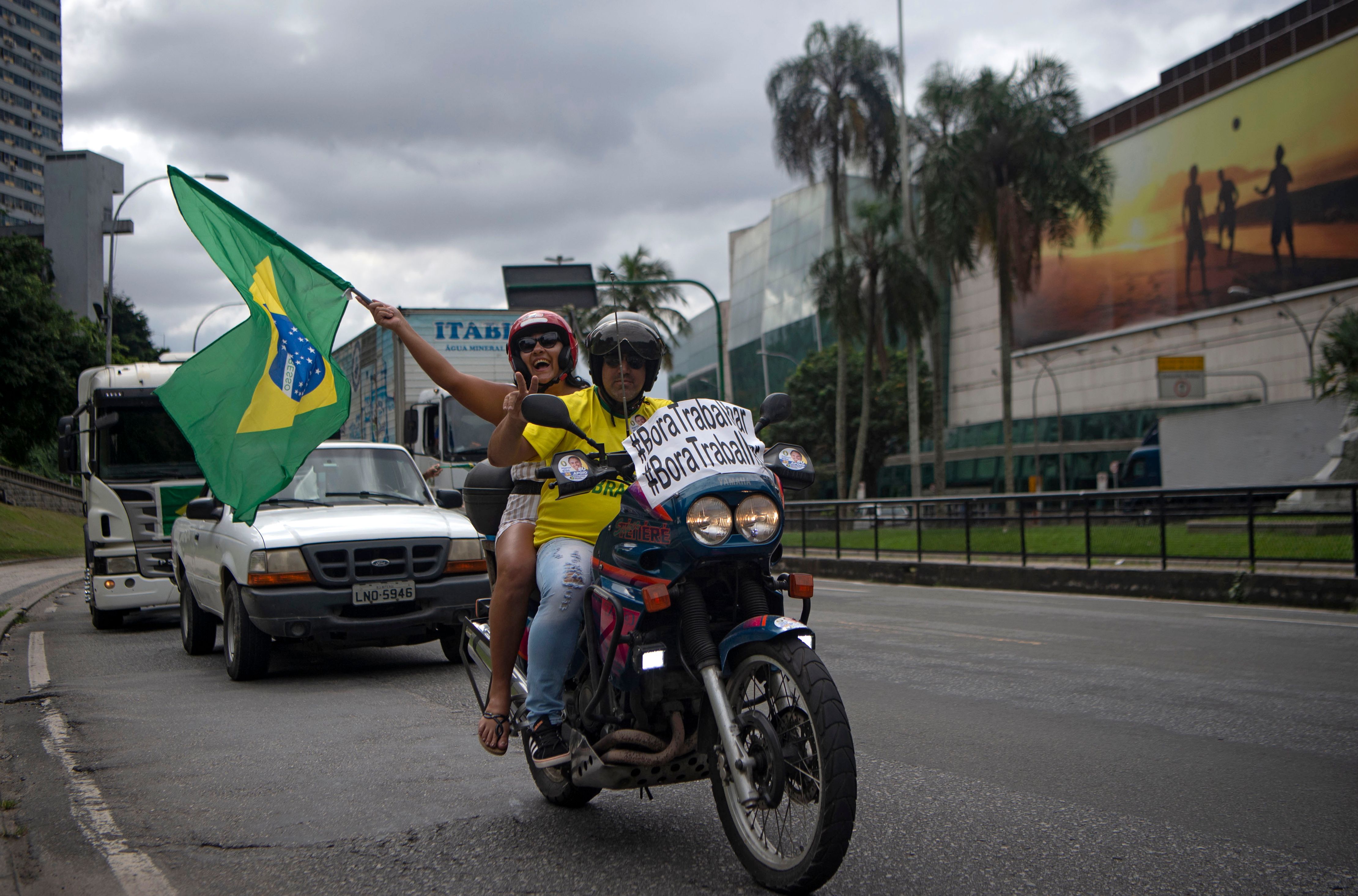 Pengendara motor meneriakkan dukungan kepada Presiden Brasil untuk mencabut kebijakan lockdown.
