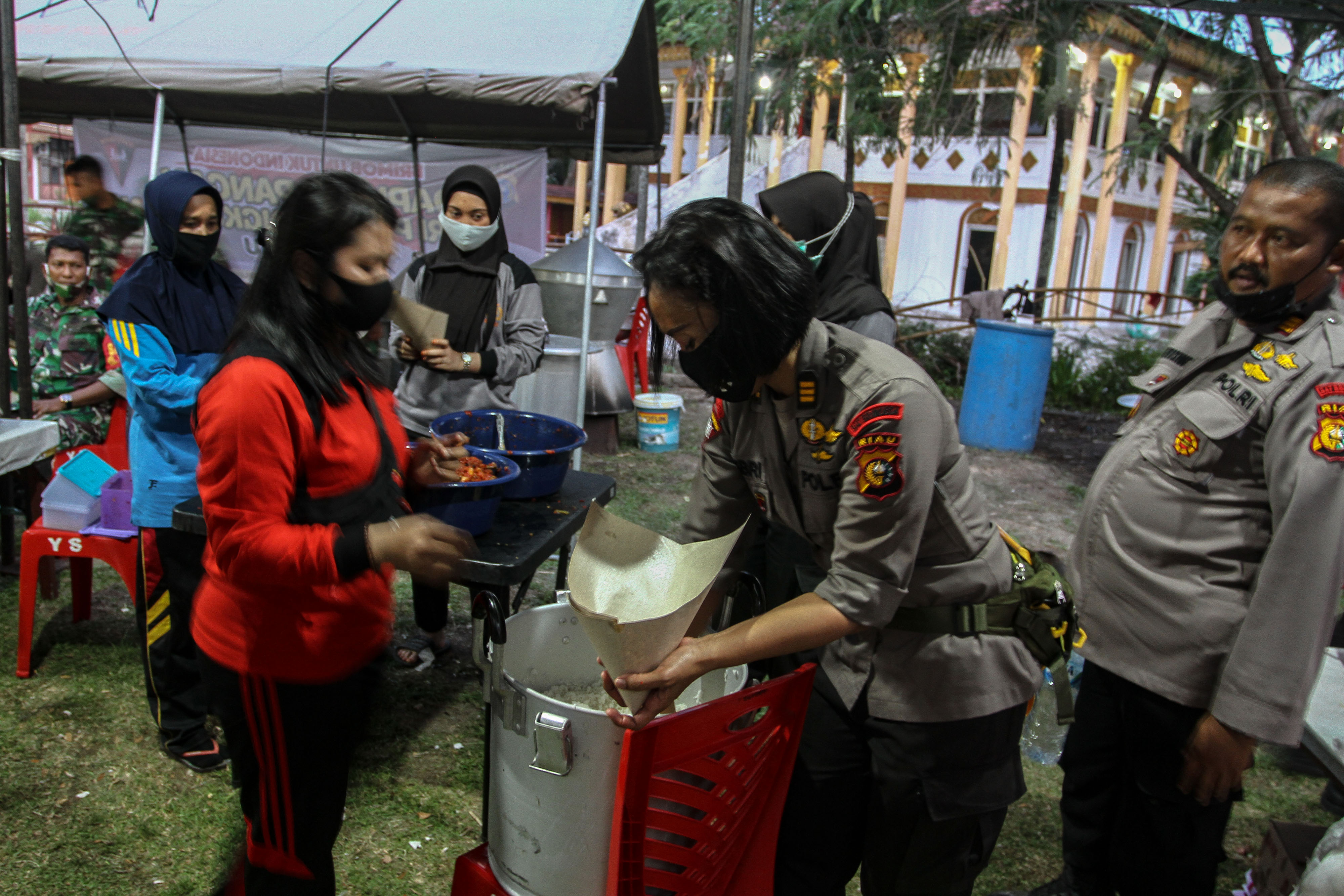 Anggota TNI dari Korem 031/WB dan personel Kepolisian Polda Riau menyiapkan masakan di dapur umum TNI POLRI Peduli Kemanusiaan di Pekanbaru.
