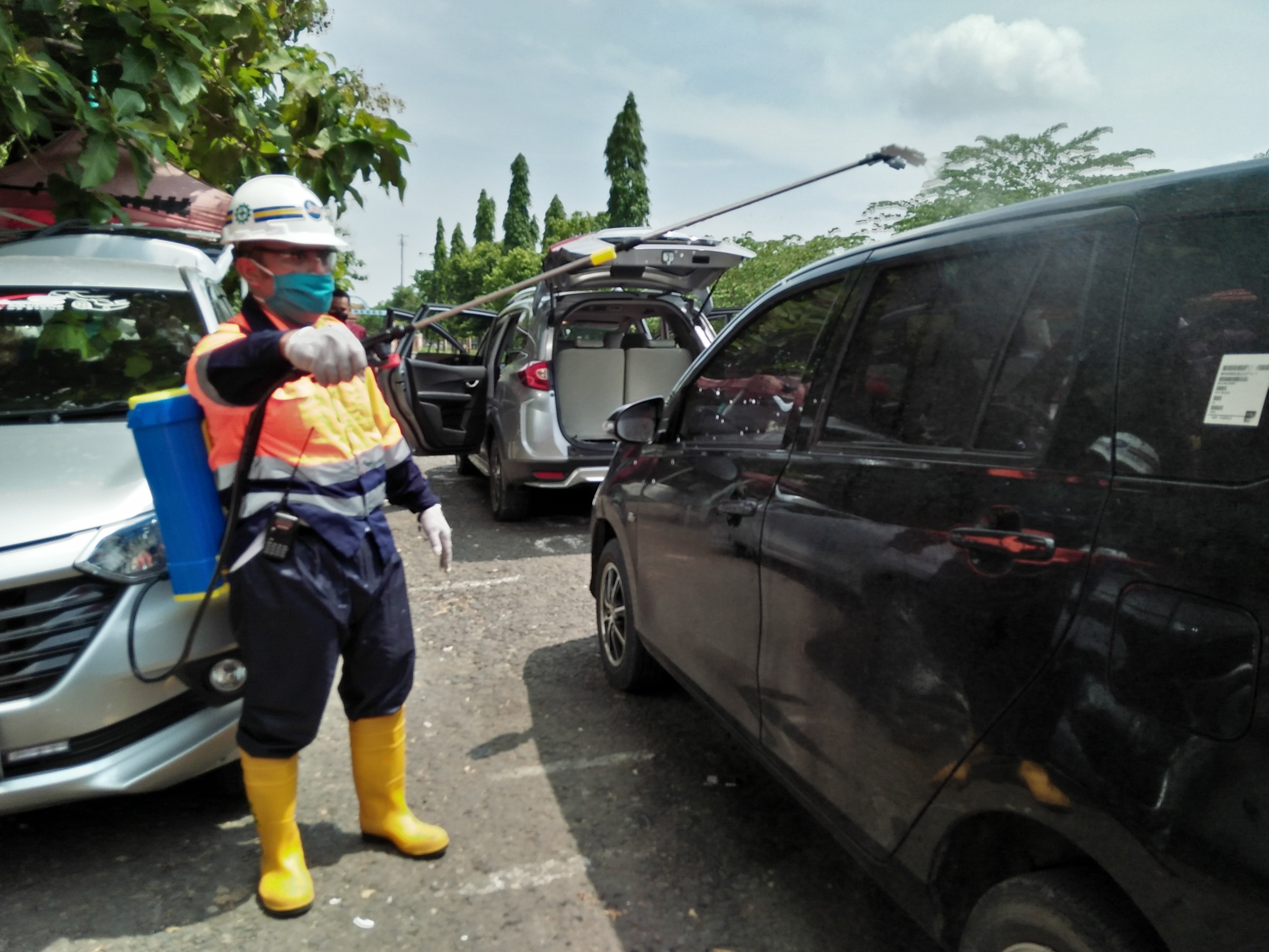 Relawan komunitas driver online Brebes-Tegal sedang menyemprot mobil anggota di halaman Islamic Center Brebes, Sabtu (18/4).