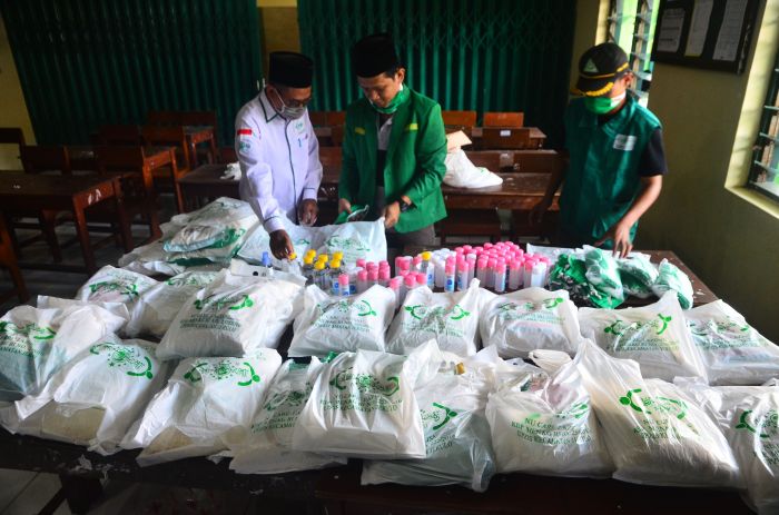 Anggota Gerakan Pemuda Ansor (GP Ansor) menyiapkan paket sembako yang akan dibagikan warga di Kudus, Jawa Tengah, Sabtu (4/4).