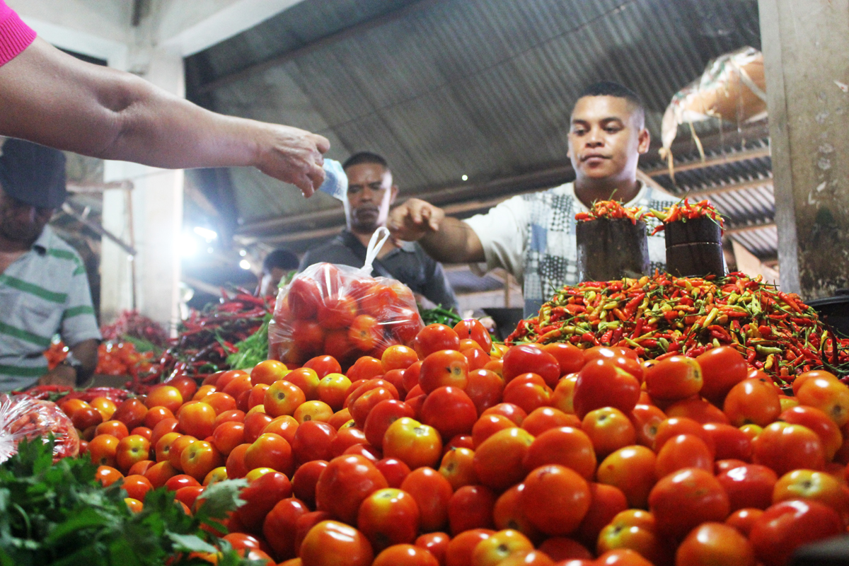 Pedagang dan pembeli melakukan transaksi jual beli tomat di Pasar Kasih di Kelurahan Naikoten 1, Kota Kupang, NTT.