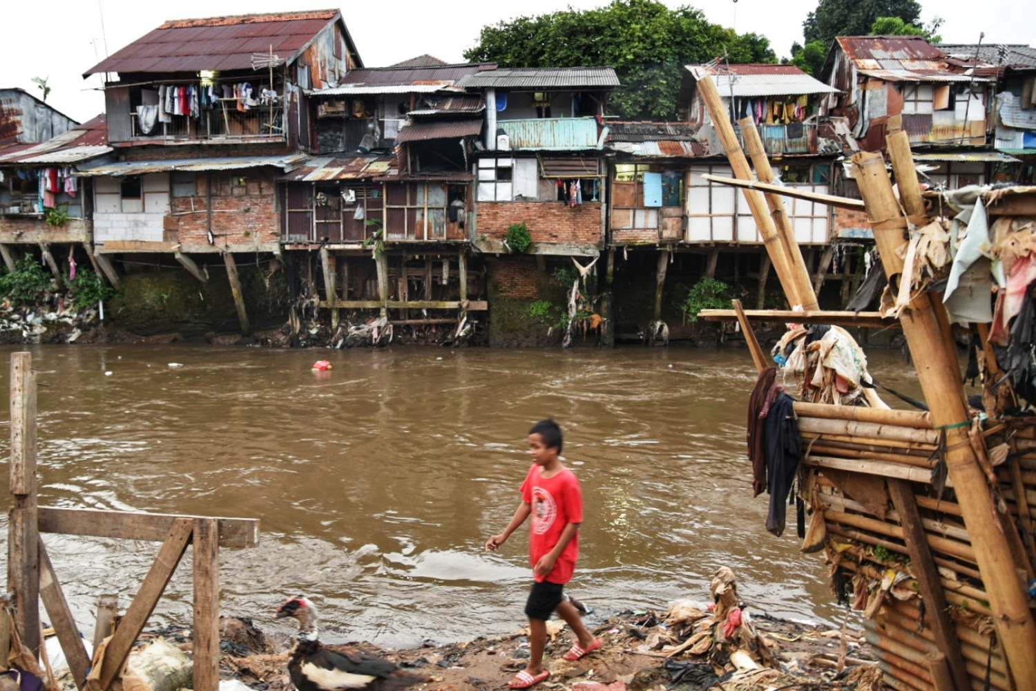 Warga beraktivitas di pemukiman padat penduduk di bantaran Sungai Ciliwung, Manggarai, Jakarta Selatan, Rabu (15/4)