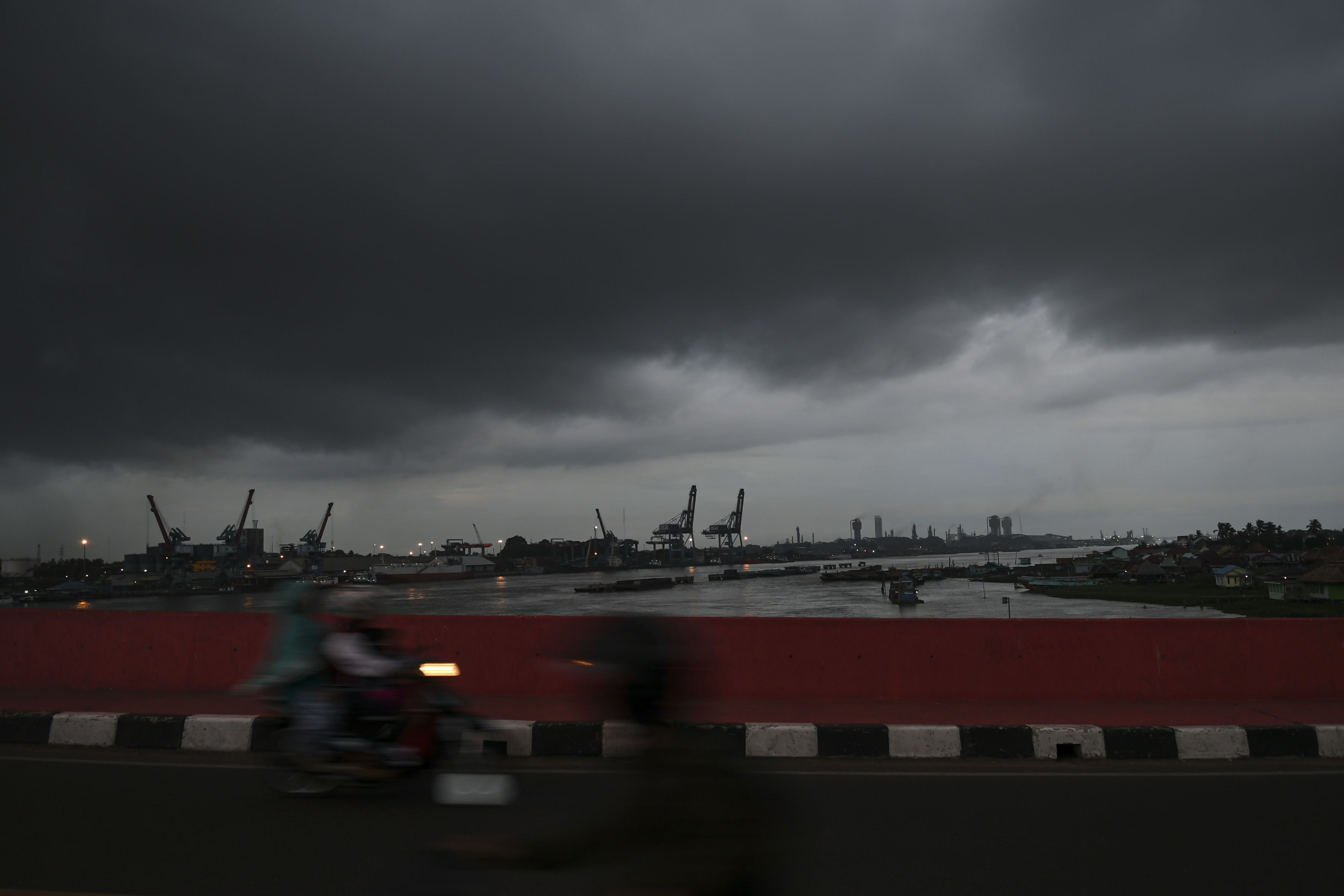 Pengendara melintas diatas jembatan musi IV dengan latar belakang awan hitam yang menyelimuti langit Palembang.
