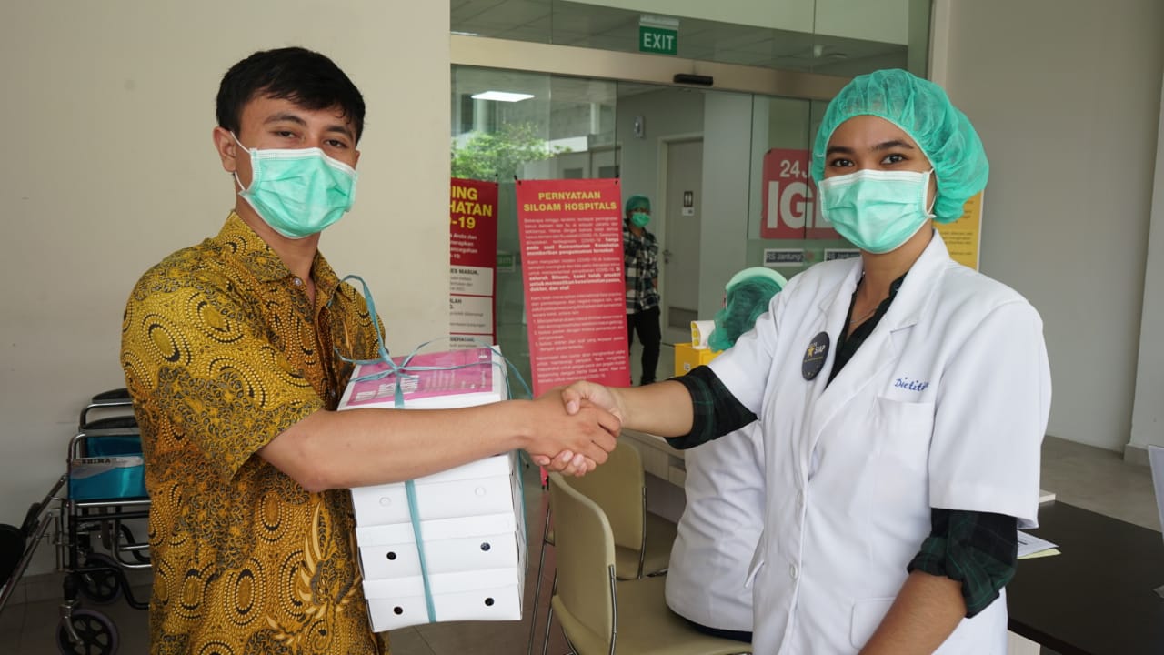 Diana Dewi saat memberikam bantuan berupa makanan ke petugas medis