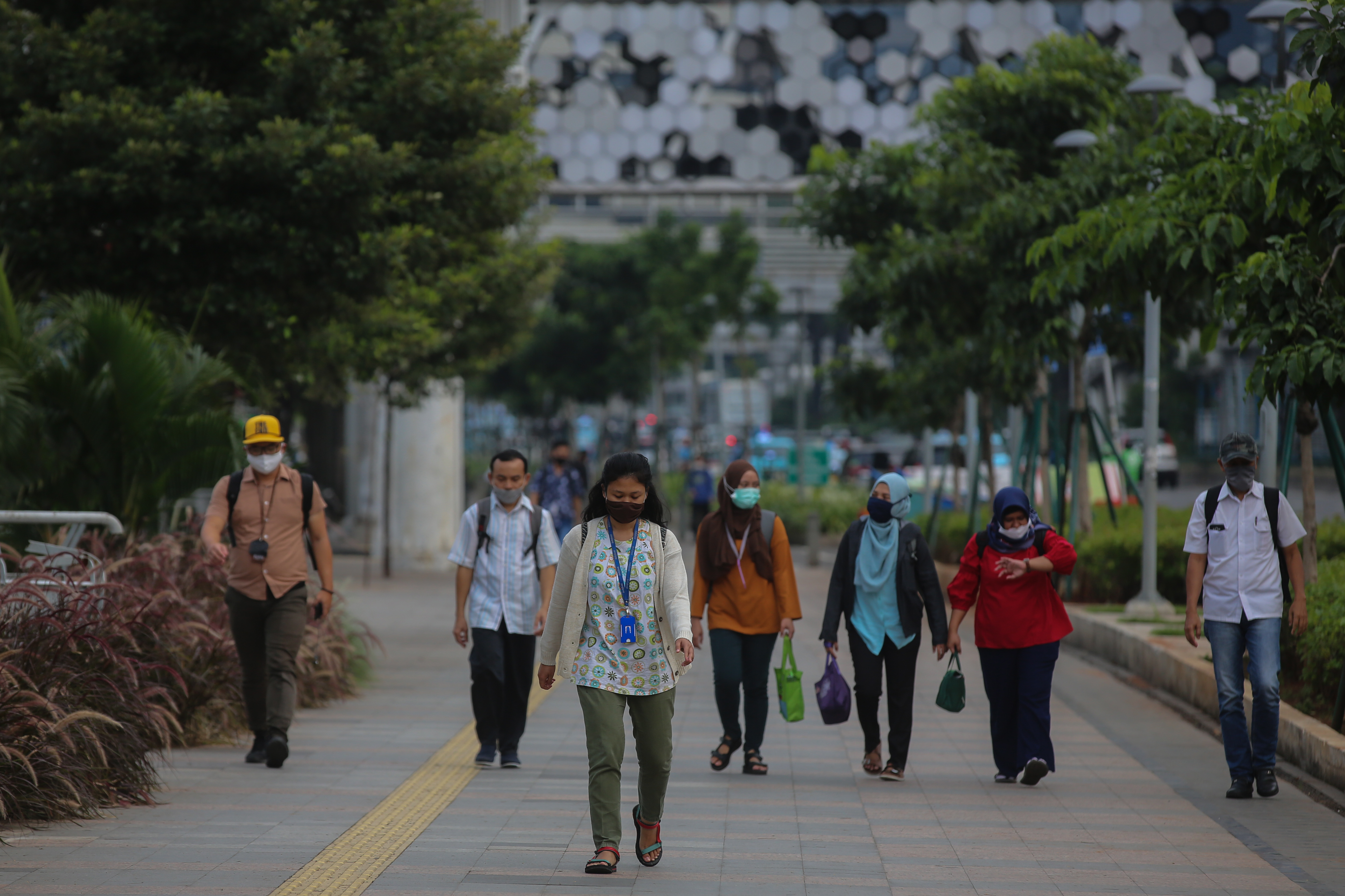 Pekerja melewati trotoar selepas jam kantor di kawasan Sudirman, Jakarta, Selasa (21/4/2020).