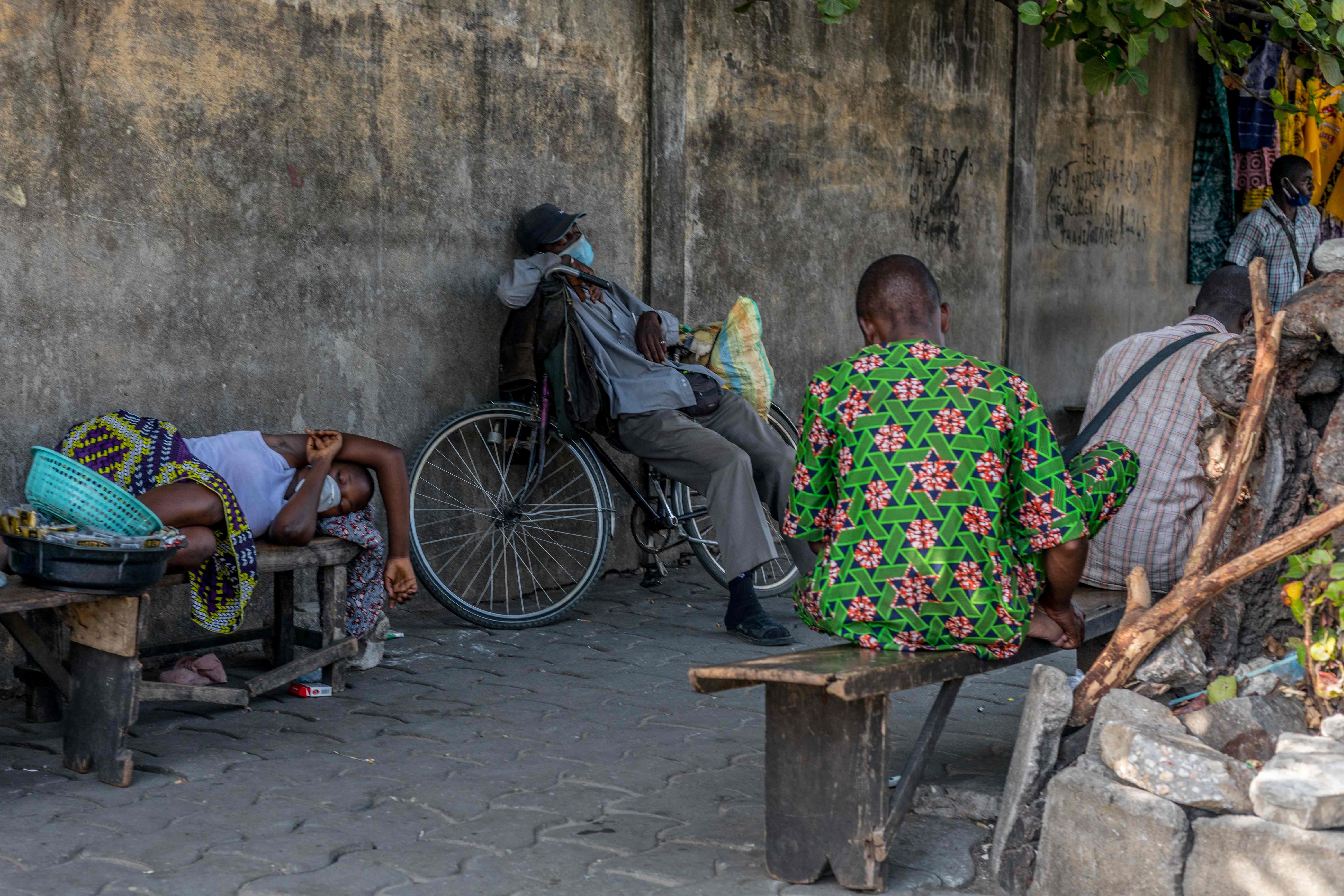 Warga kota  Benin, di Afrika beristirahat sambil menggunakan masker guna memerangi penyebaran virus covid-19