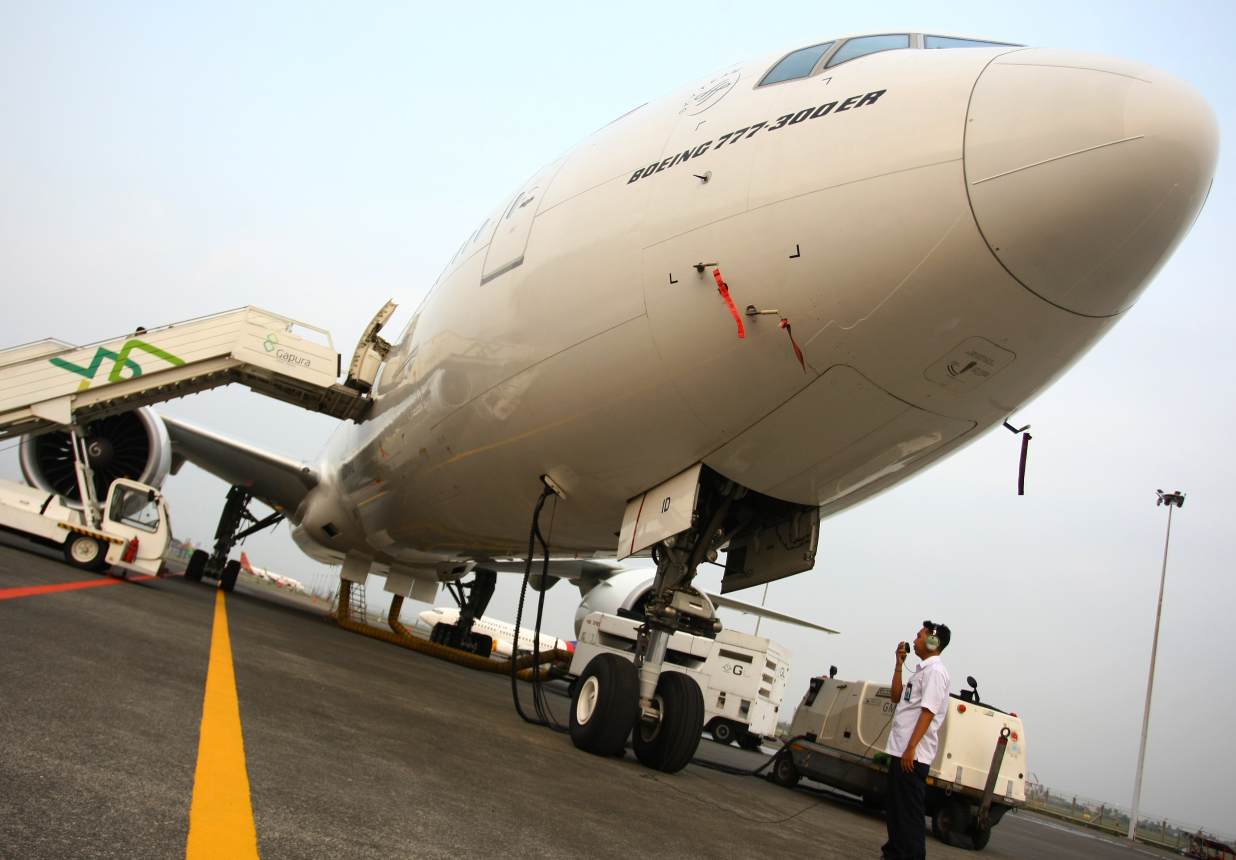 Petugas memeriksa pesawat Garuda Indonesia di Bandara Soekarno Hatta.