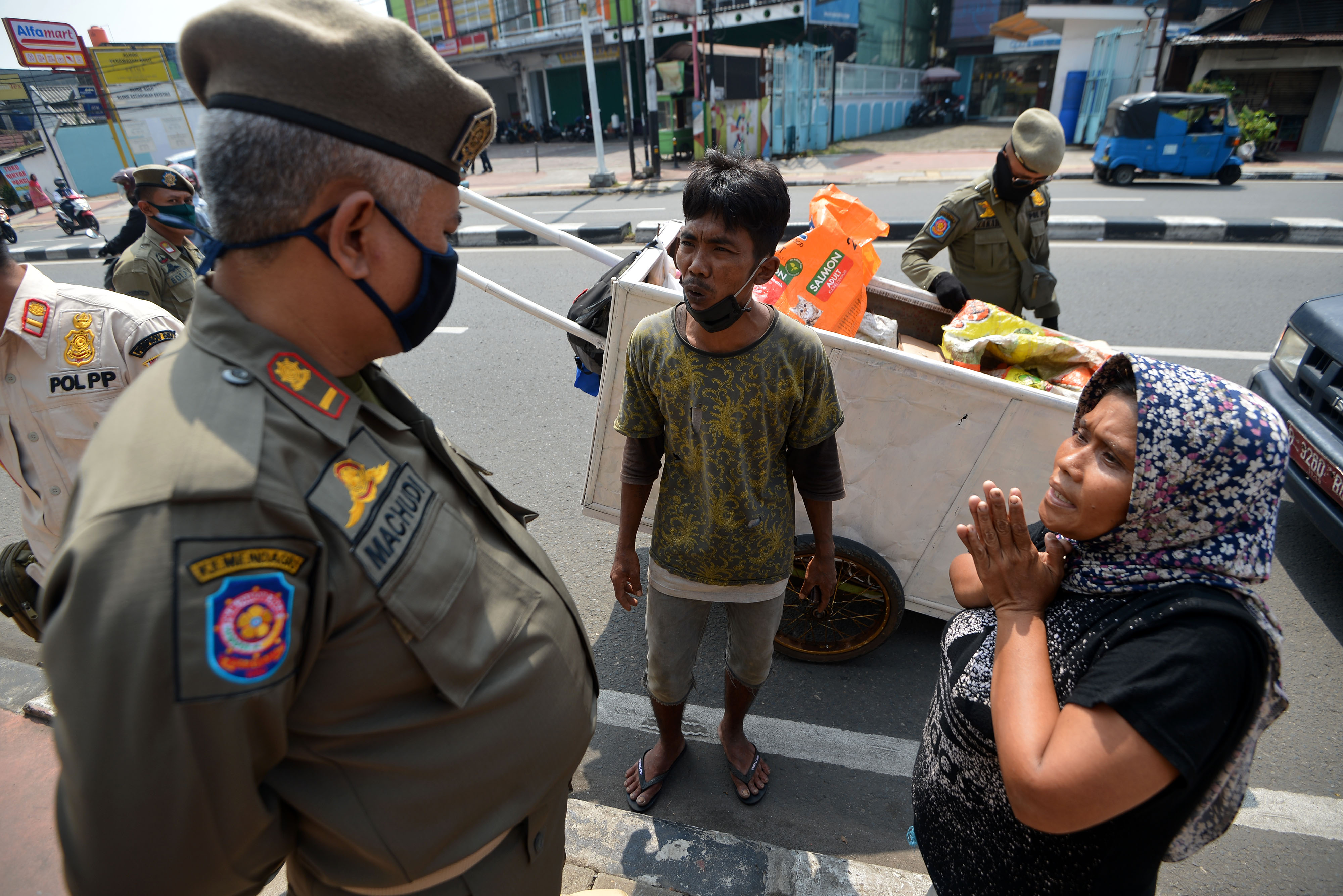 Salah satu petugas Satpol PP menegur warga langgar PSBB