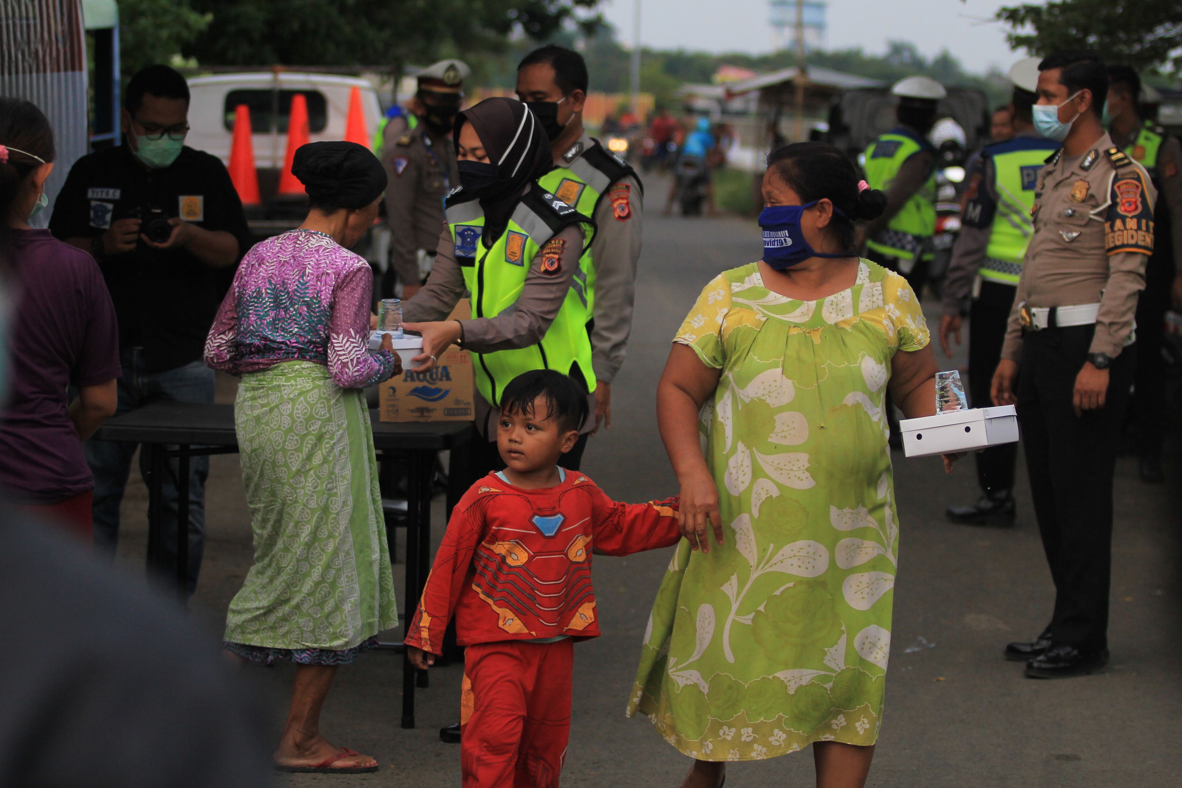  Polisi membagikan makanan untuk berbuka puasa kepada warga di kelurahan Bojongsari, Indramayu, Jawa Barat, Rabu (6/5).