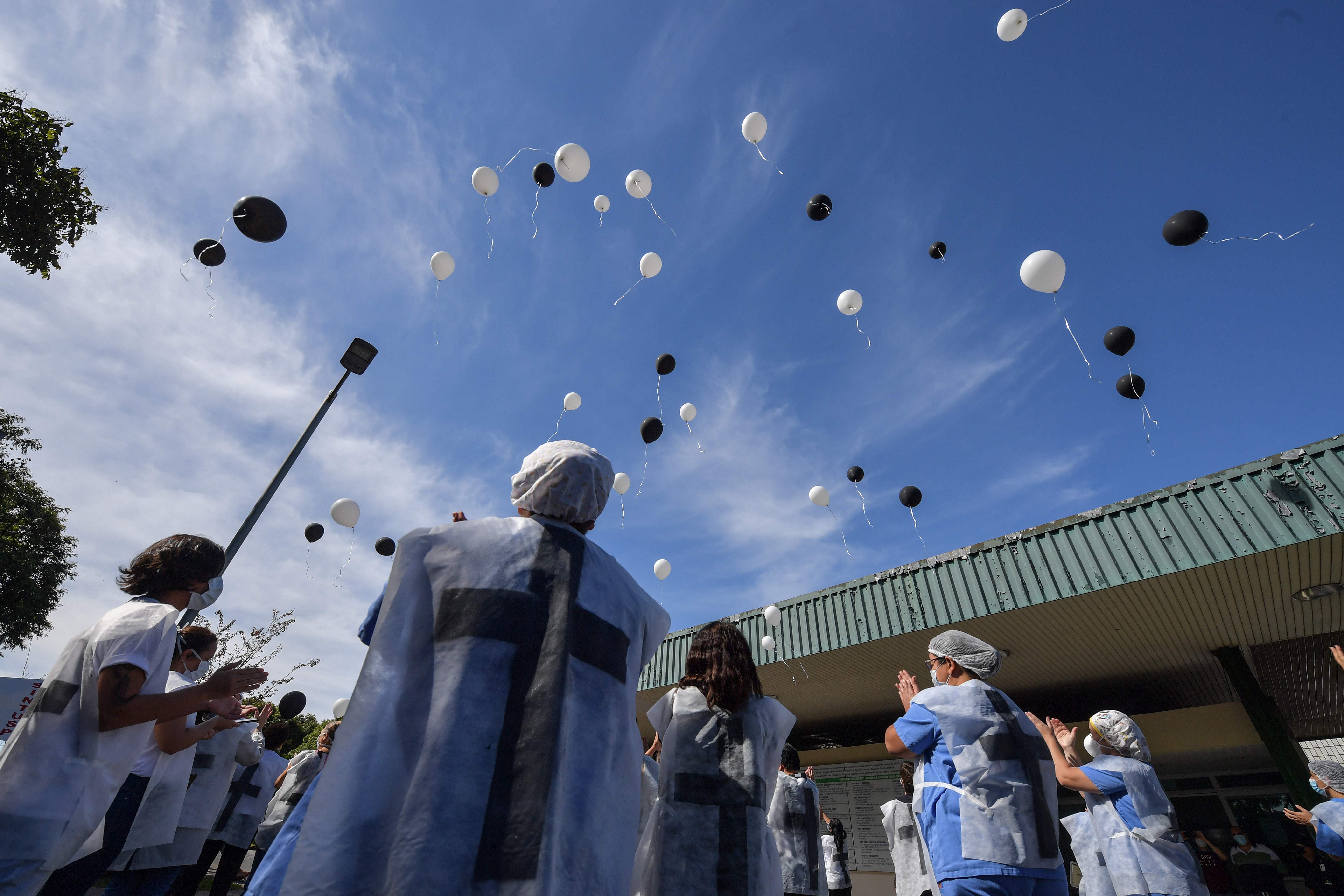 Pekerja kesehatan di Sao Paulo, Brasil melepaskan balon untuk mengenang rekan mereka yang meninggal karena covid-19.