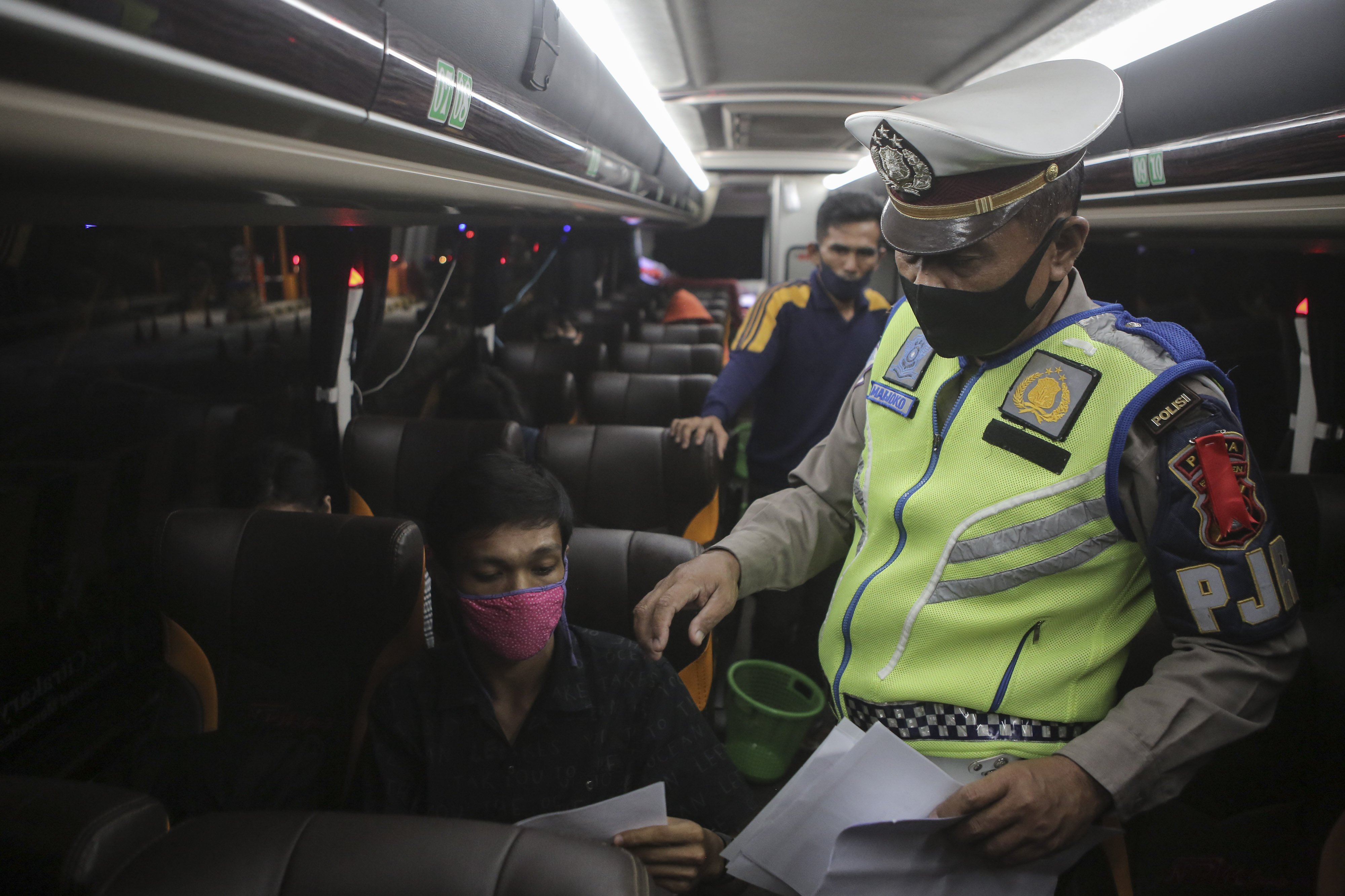 Petugas Kepolisian melakukan pemeriksaan surat-surat dan barang bawaan kepada penumpang kendaraan melintas di Tol Merak, Banten