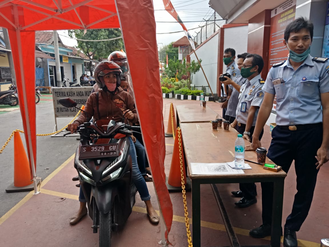 Keluarga WBP melewati layanan drive thru untuk menitipkan barang bagi anggota keluarga mereka di Rutan Medaeng, Surabaya.
