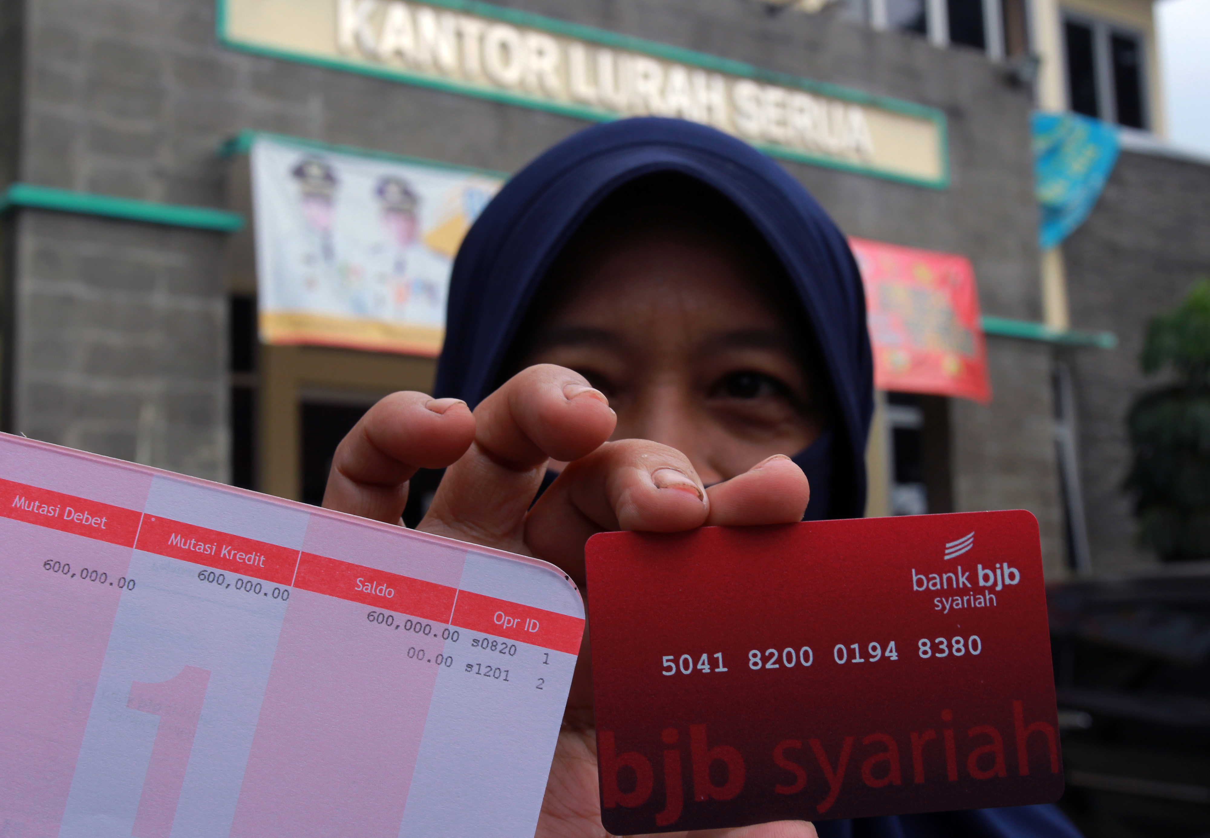 Warga menunjukan buku tabungan dan kartu ATM di Serua, Tangerang Selatan, Banten, Rabu (6/5).