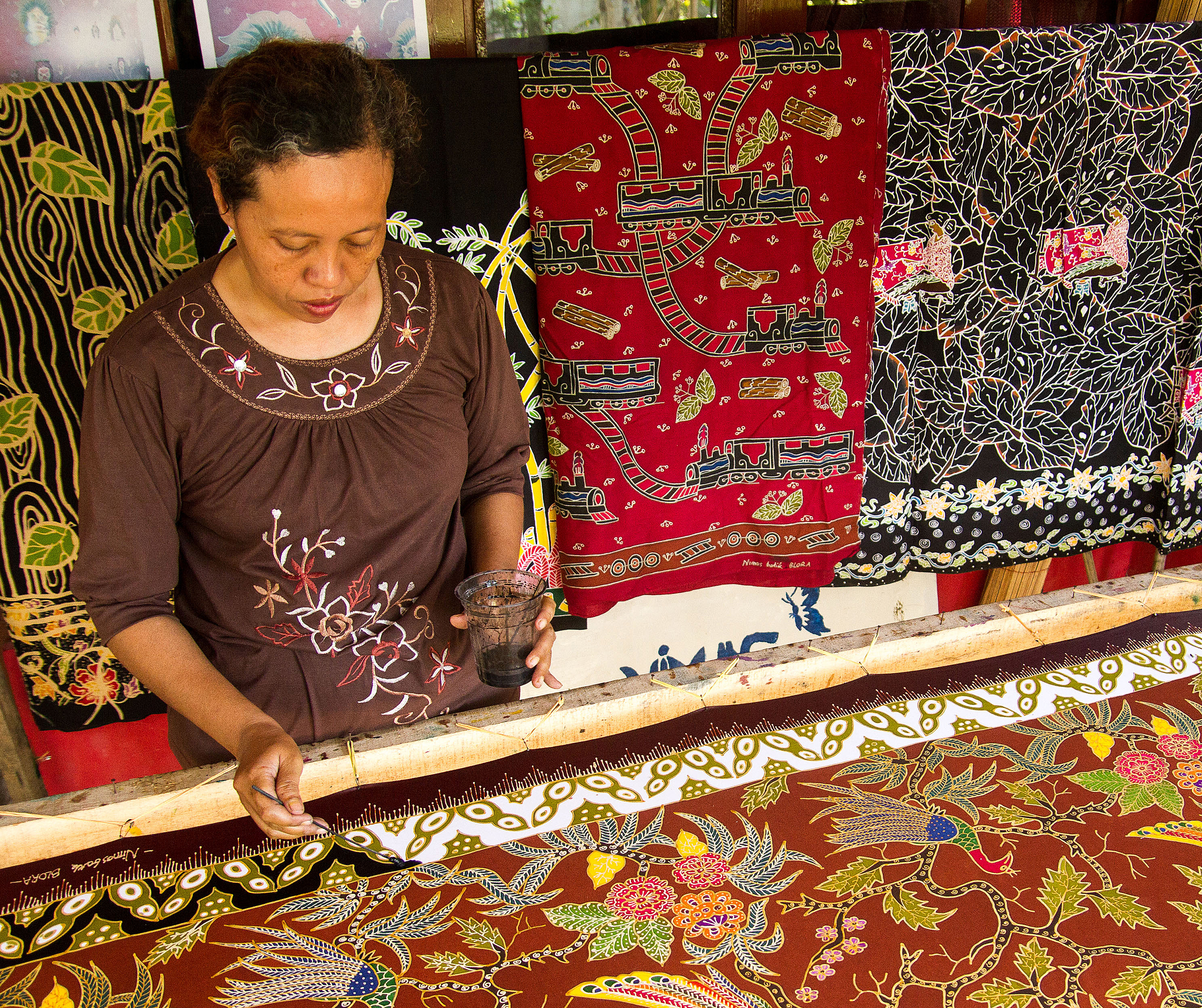 Pembatik mengerjakan pesanan batik tulis bermotif burung merak dan daun jati di sebuah industri rumahan di Desa Beran, Kabupaten Blora