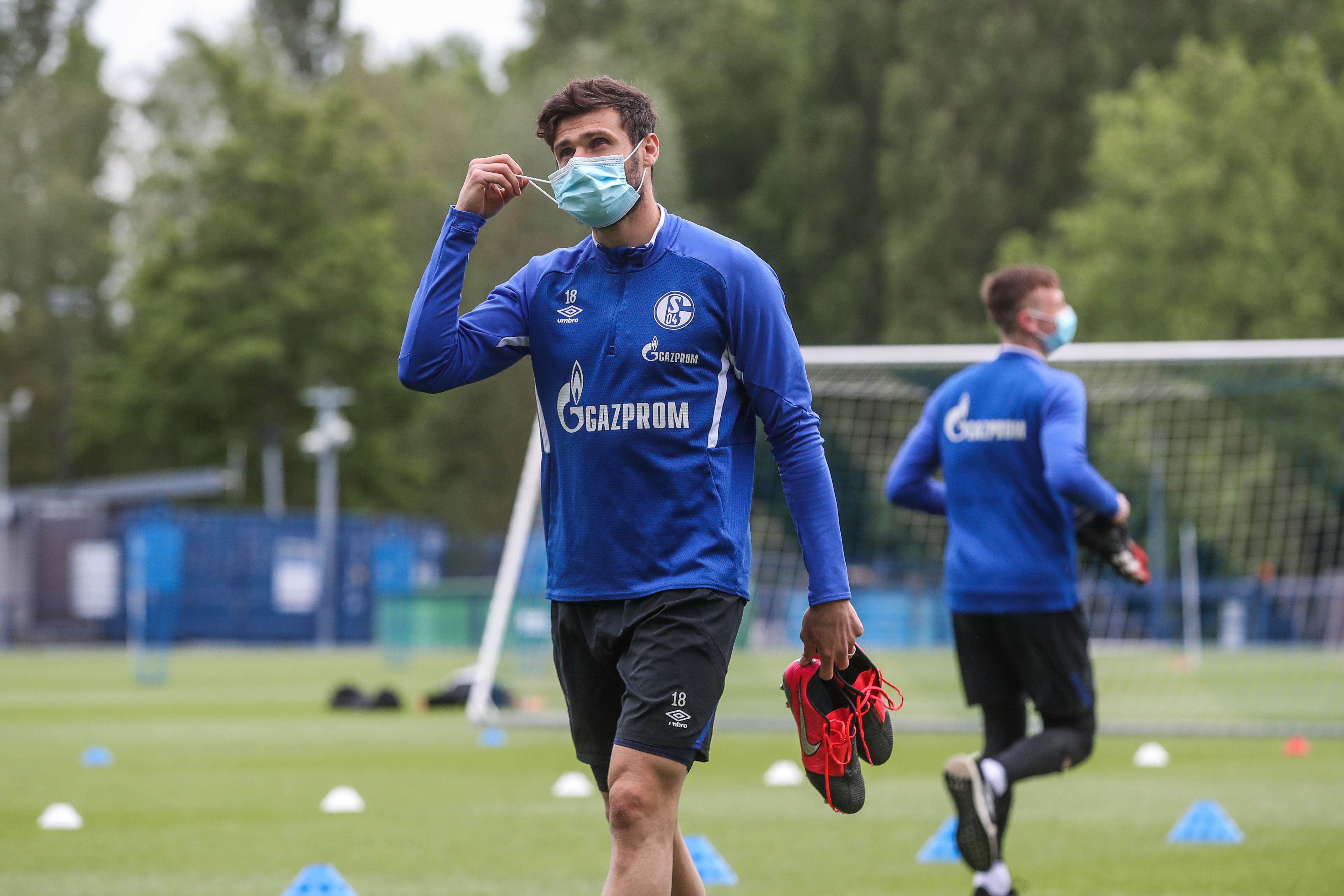 Pesepak bola Daniel Caligiuri menggunakan masker saat menjalani latihan jelang kompetisi Bundesliga.