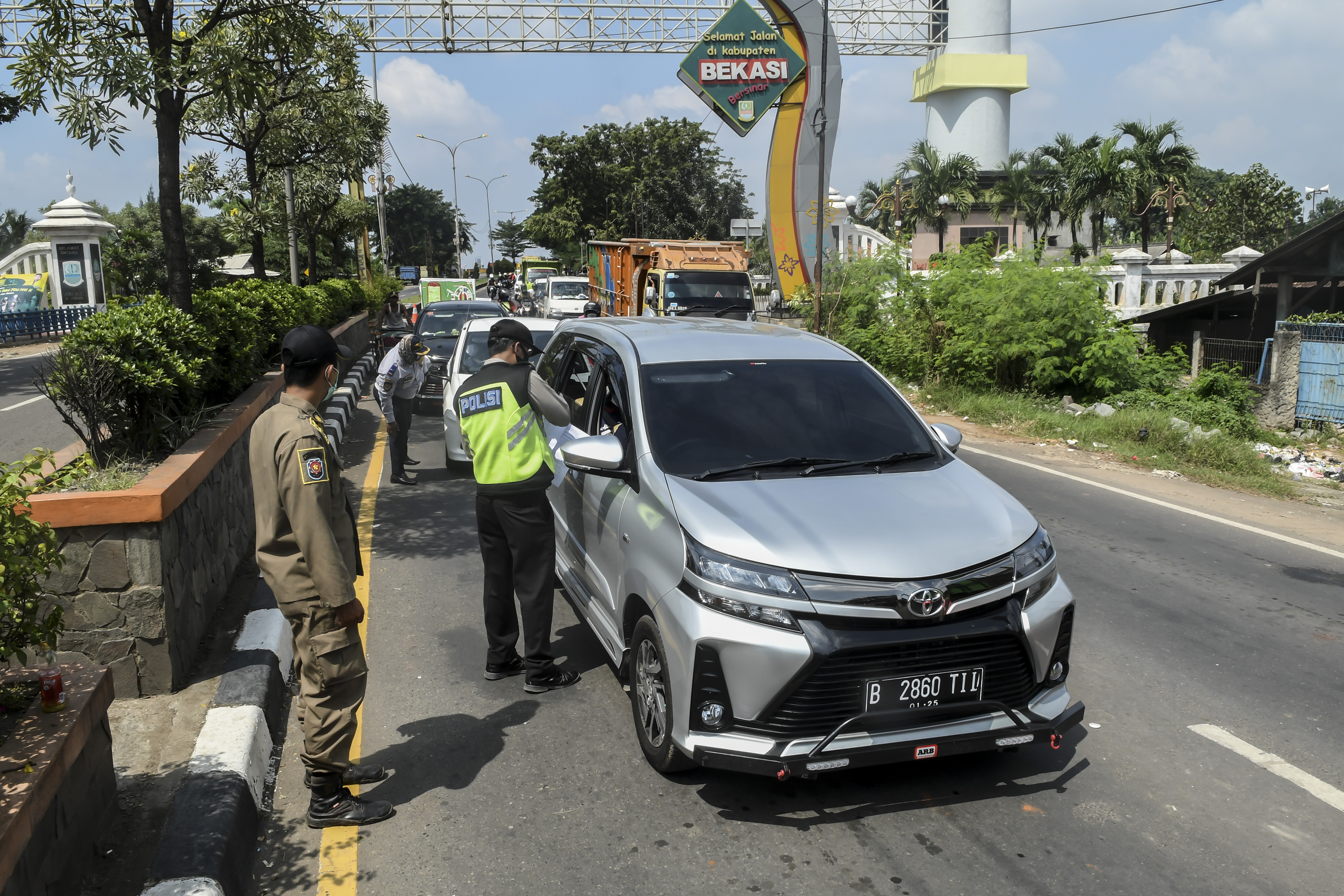Petugas memeriksa pengguna kendaraan yang akan masuk ke wilayah DKI Jakarta di kawasan perbatasan Bekasi-Karawang, Jawa Barat.