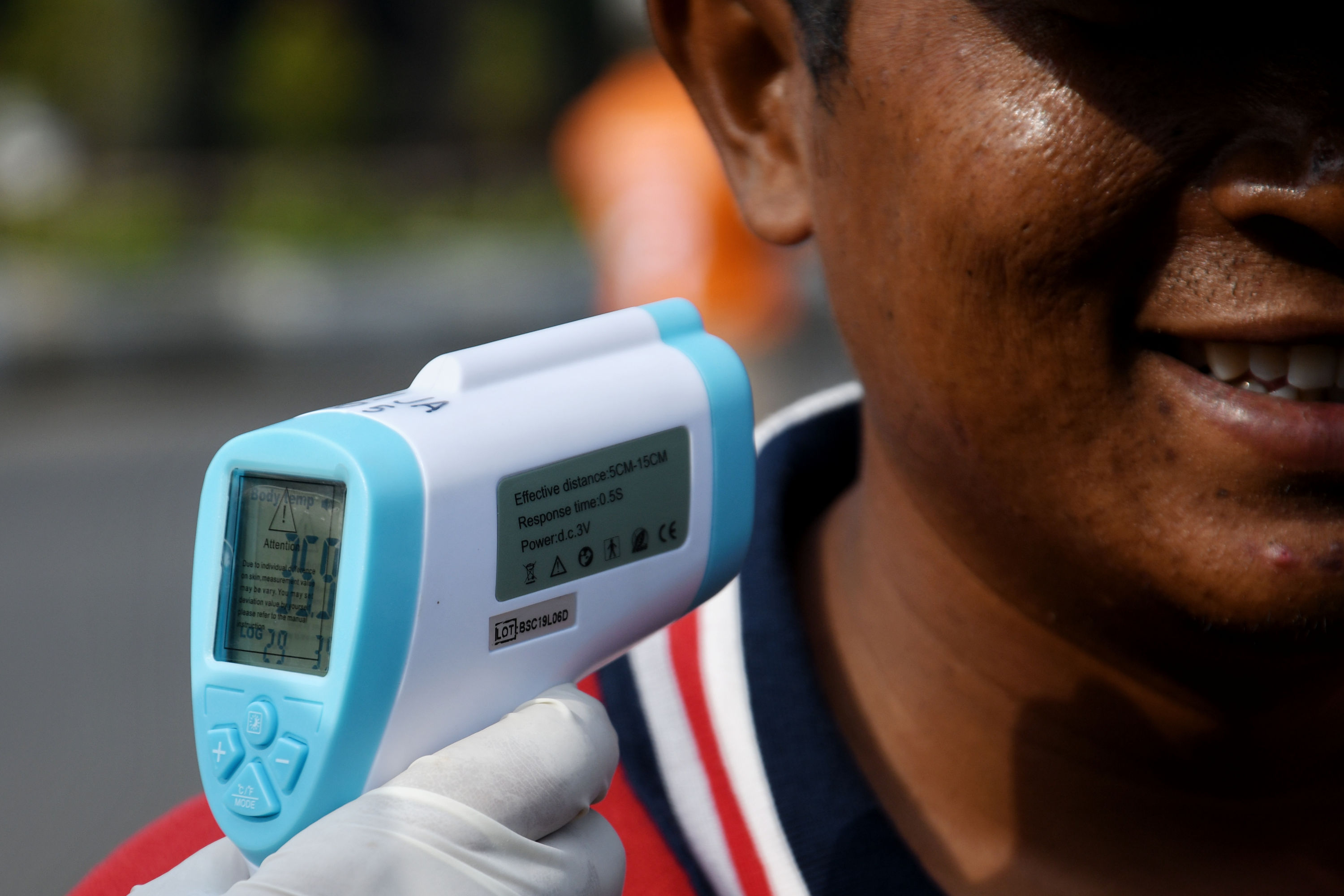 Petugas memeriksa suhu tubuh warga di kawasan Ancol, Jakarta Utara.