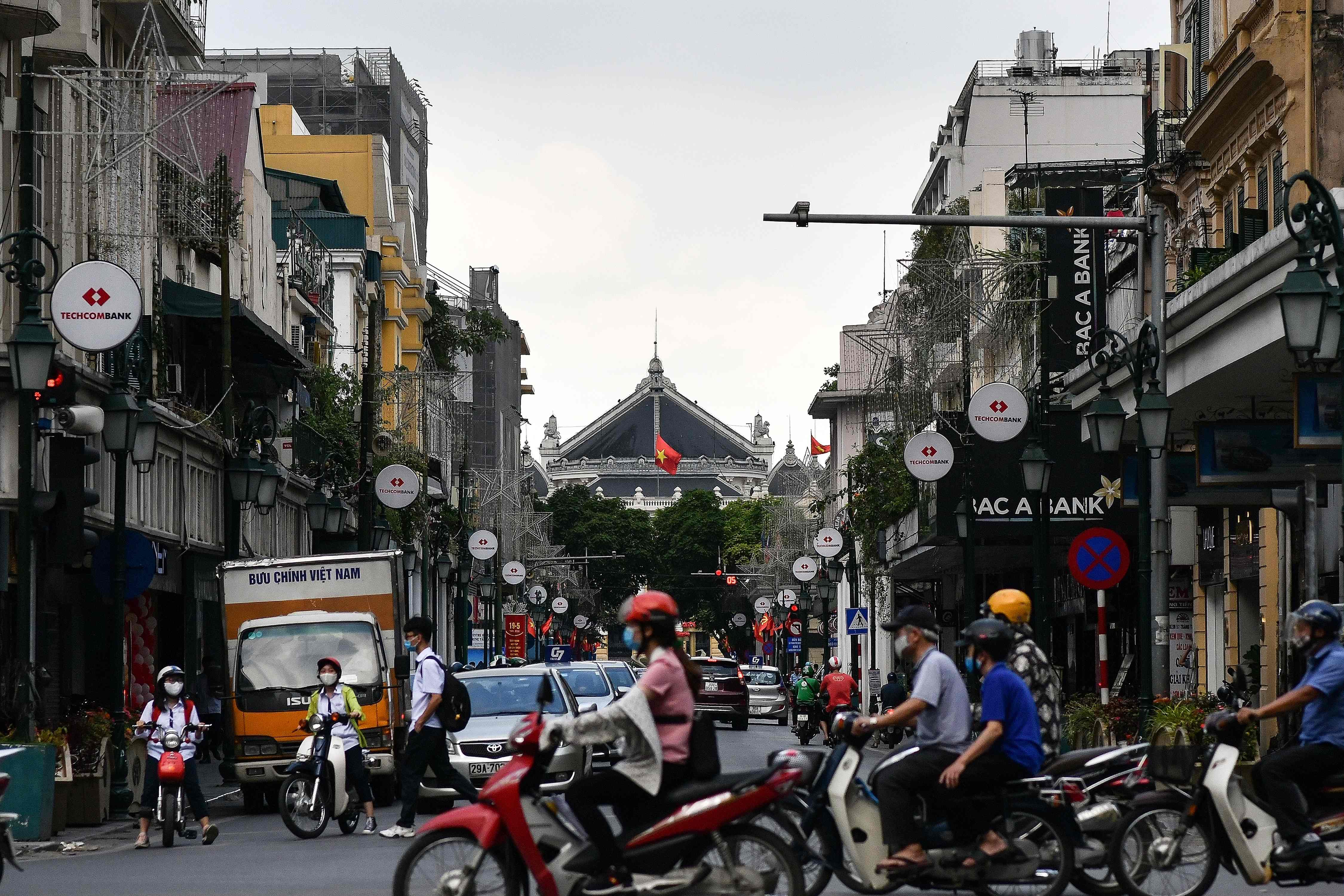 Warga memakai masker saat berkegiatan di Hanoi pada 13 Mei 2020