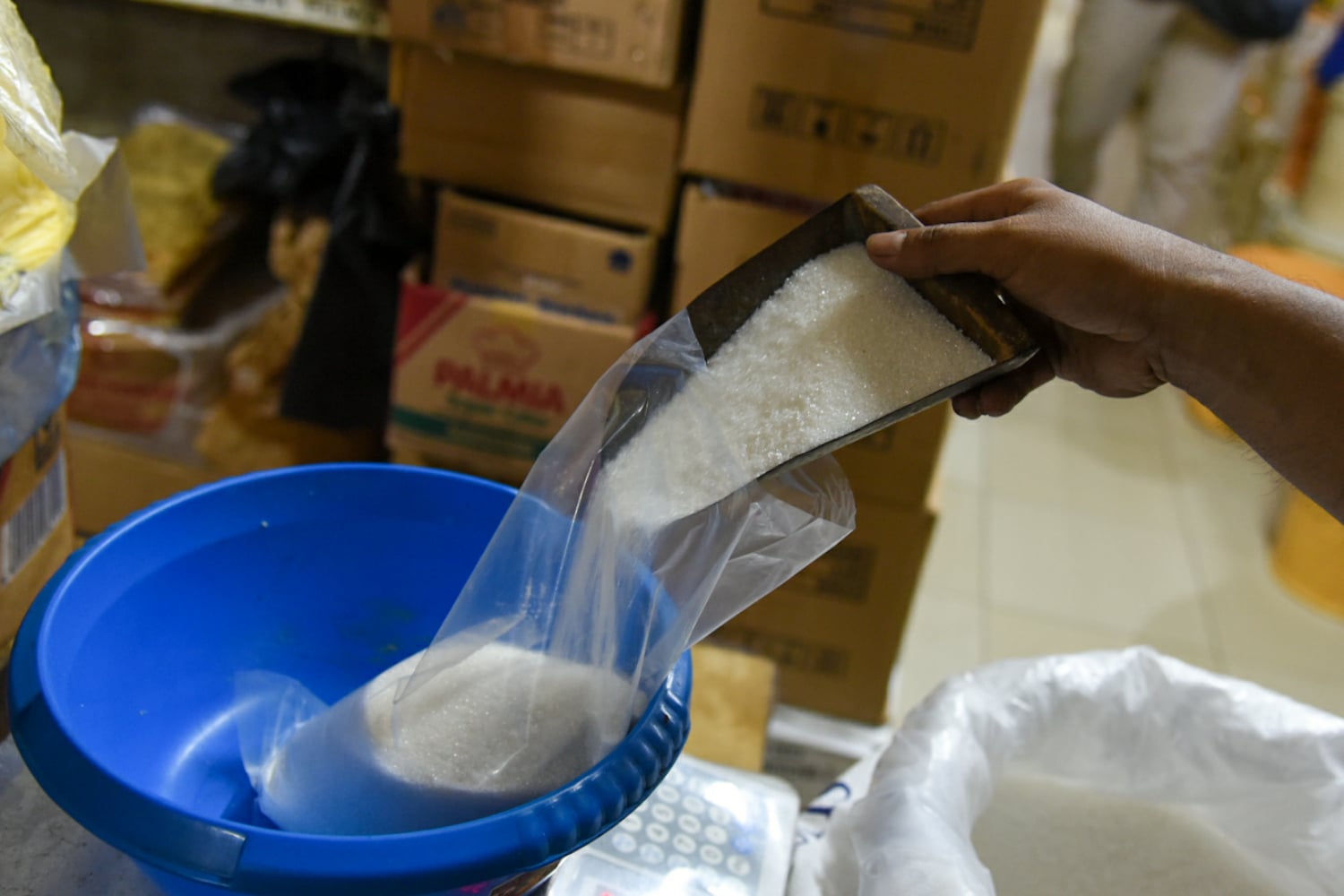 Pedagang di Pasar Jatinegara sedang menimbang gula.