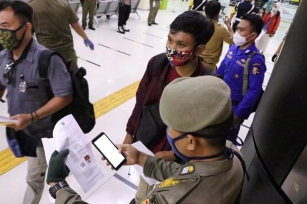 Petugas mengecek SIKM penumpang kereta di Stasiun Gambir