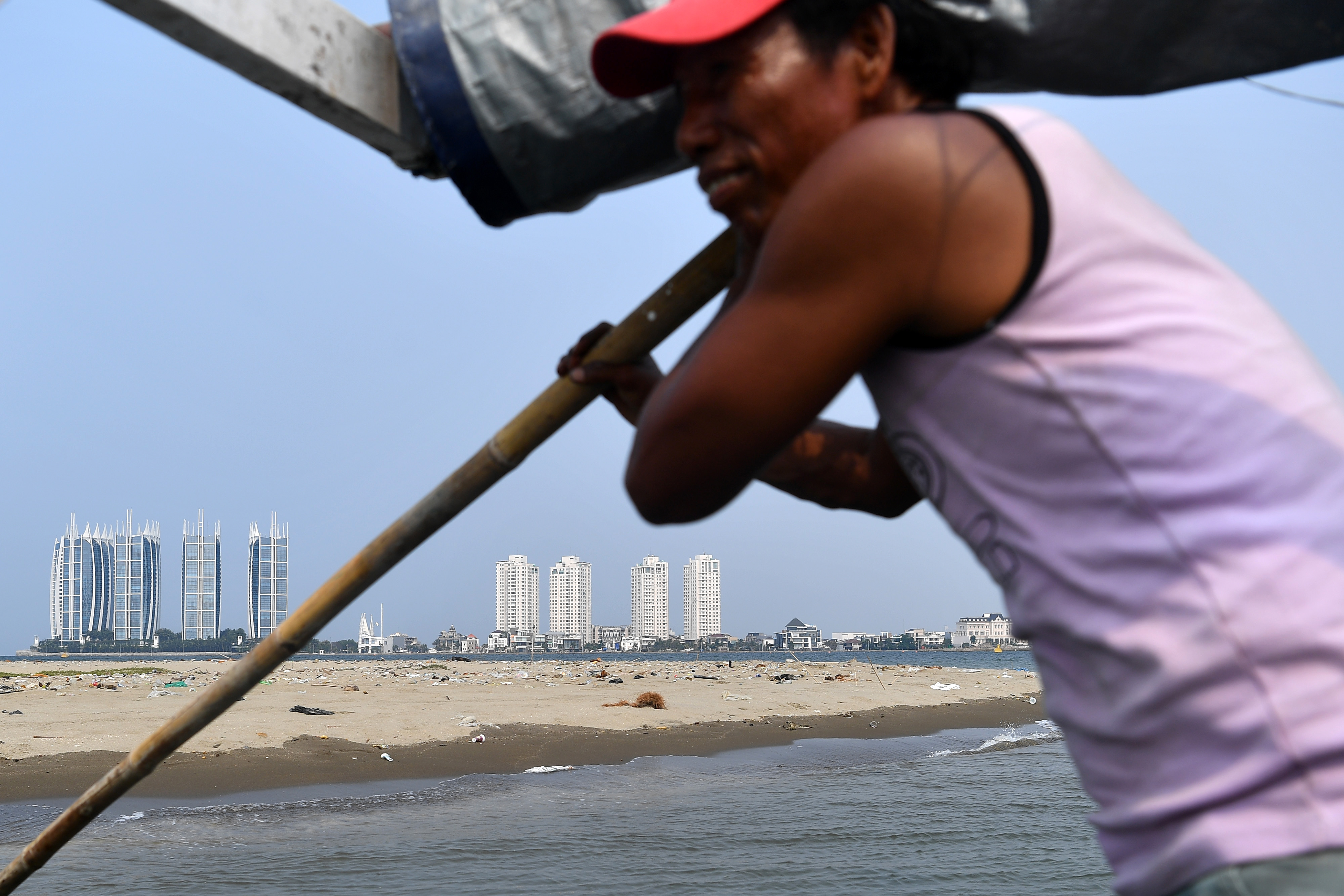 Nelayan mengendalikan kapalnya saat melintas di Pulau G, perairan Teluk Jakarta, Jakarta Utara
