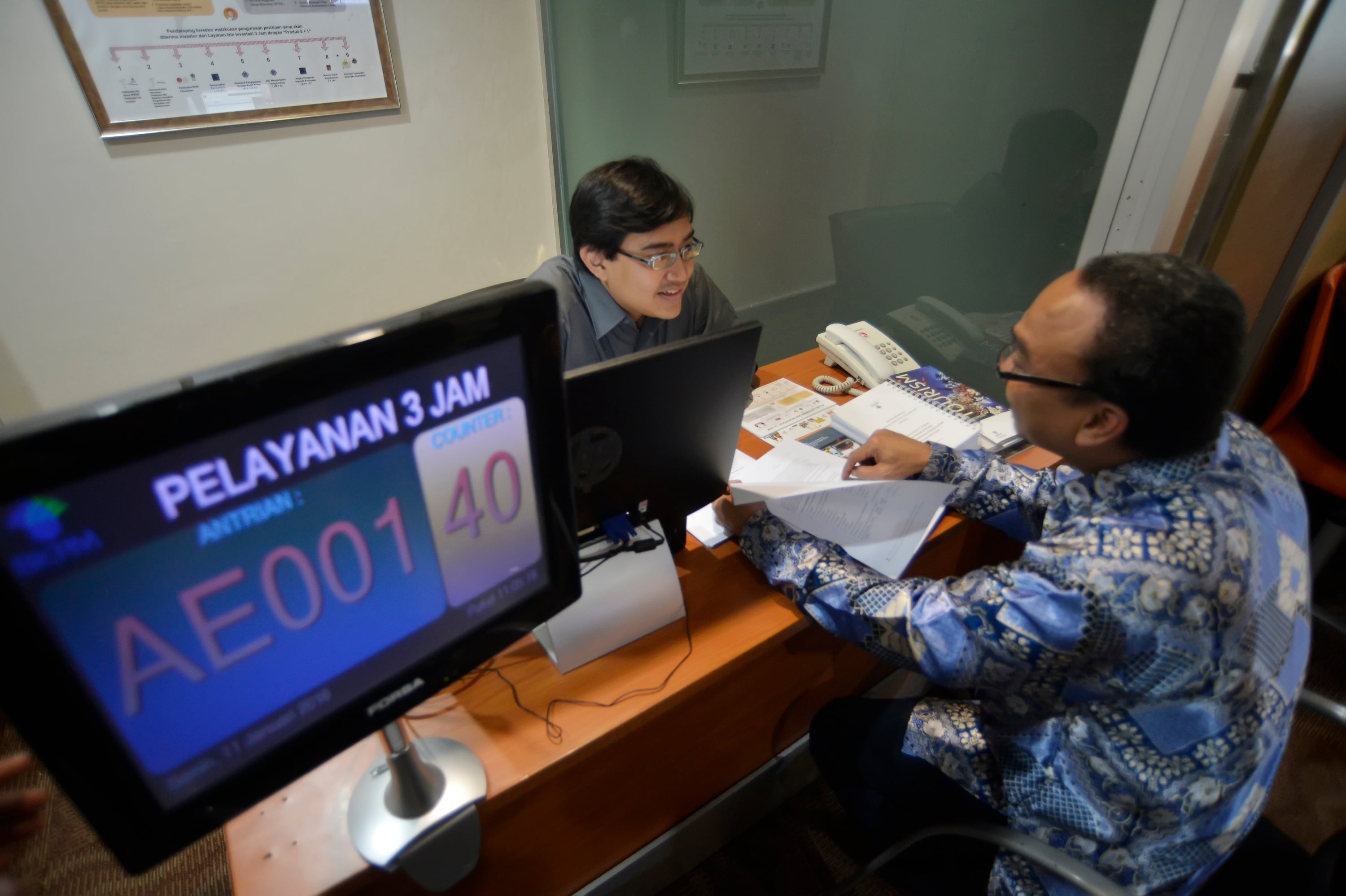 Petugas melayani calon investor dalam pengurusan Izin Investasi Tiga Jam di Gedung BKPM, Jakarta.