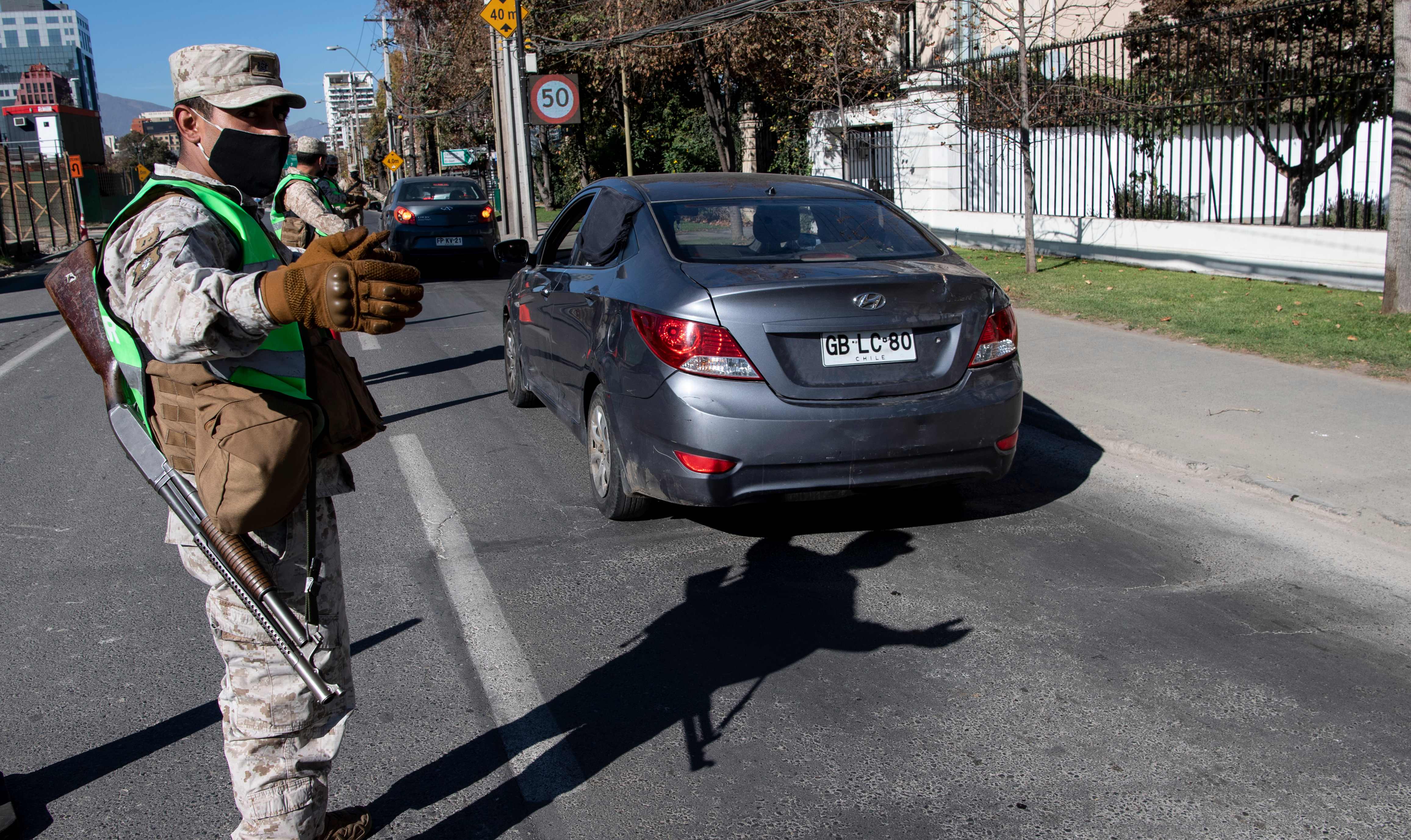 Personel militer Cile berjaga-jaga di pusat pemeriksaan kendaraan di Kota Santiago.